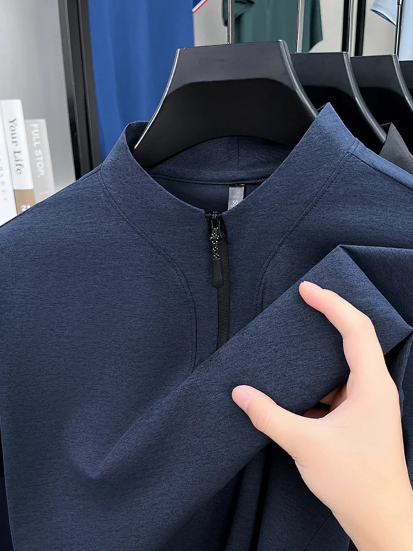 Navy quarter-zip short-sleeve top close-up of stand collar and zipper pull