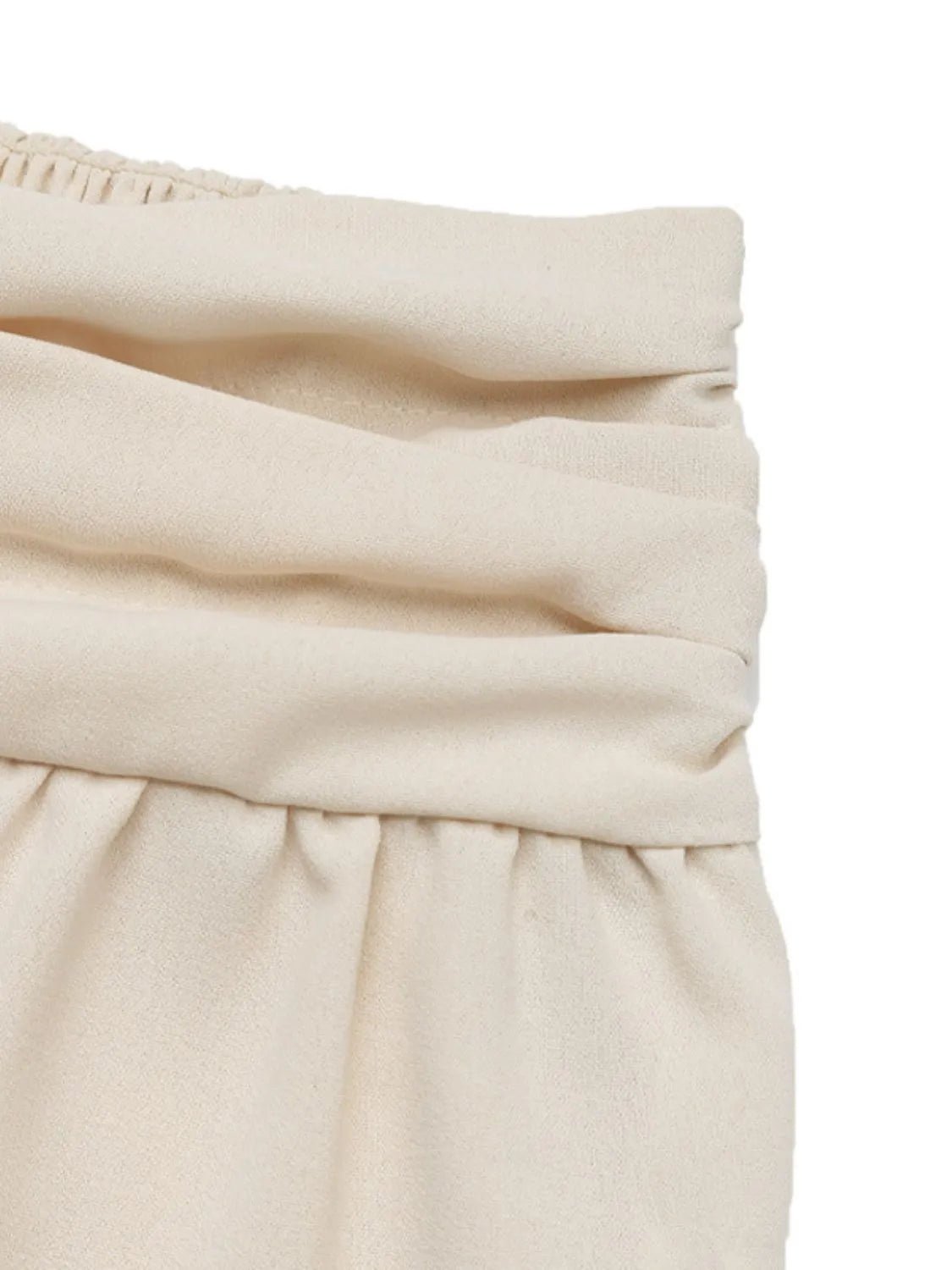 Cream joggers waistband detail with ruched, gathered fabric layers