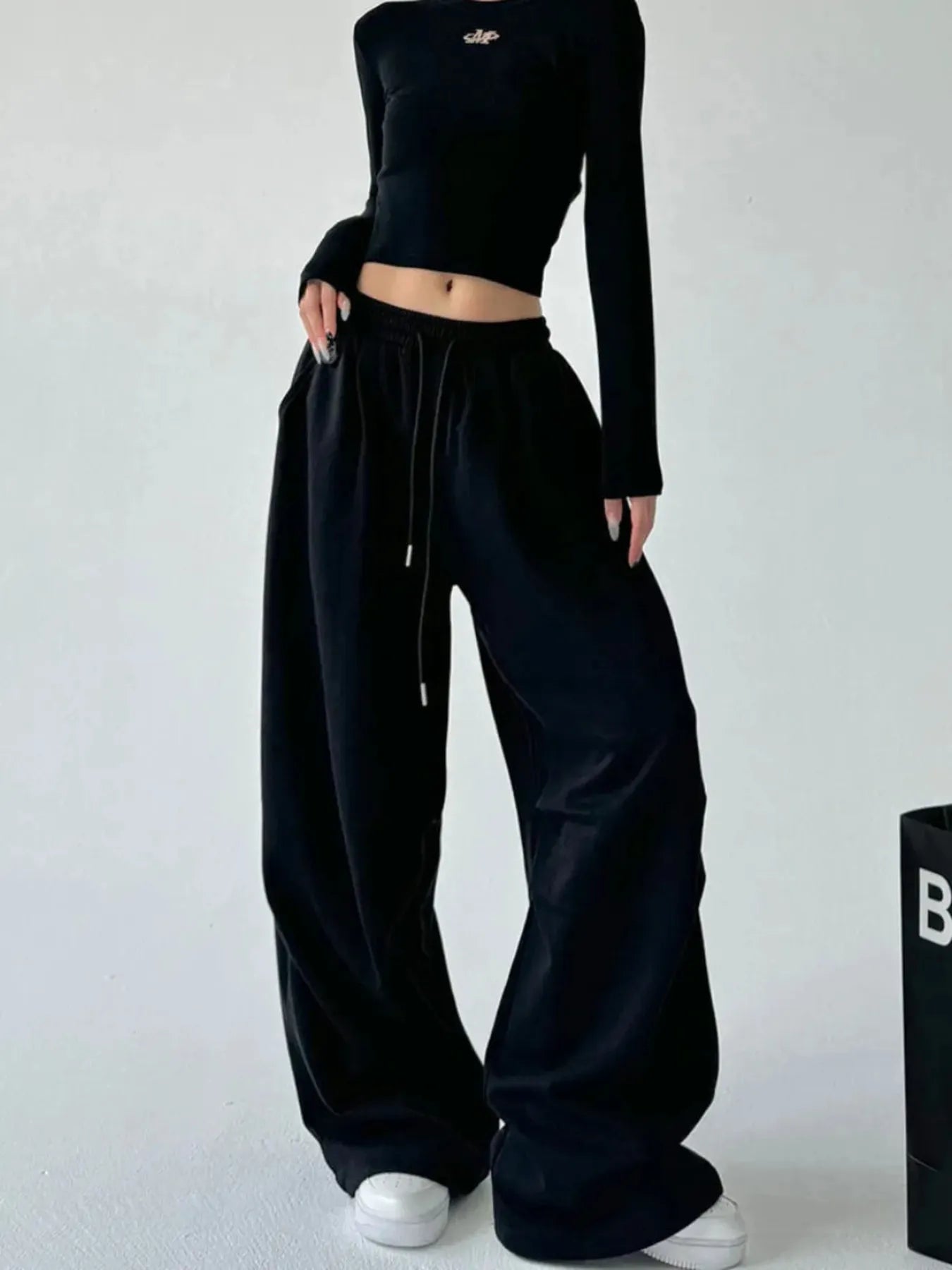 Black oversized wide-leg drawstring pants with elastic waist and long, wide legs