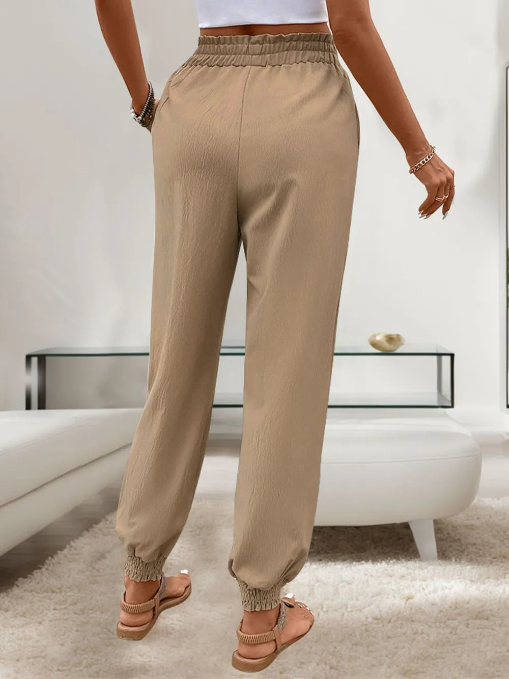 Tan elastic-waist drawstring pants with side pockets and gathered ankle cuffs
