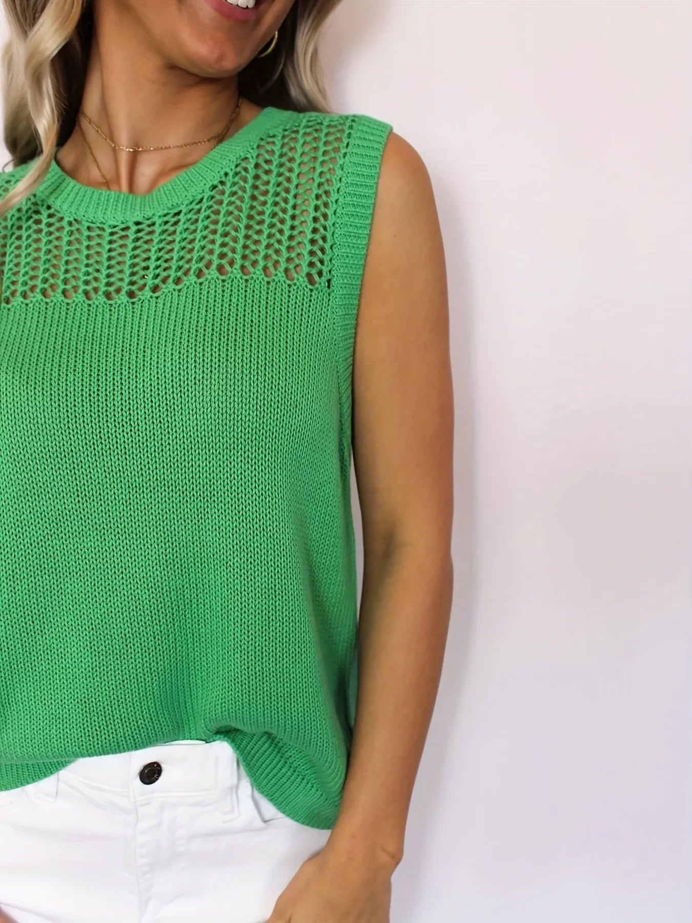 Green openwork round neck sweater vest close-up of shoulder and hem