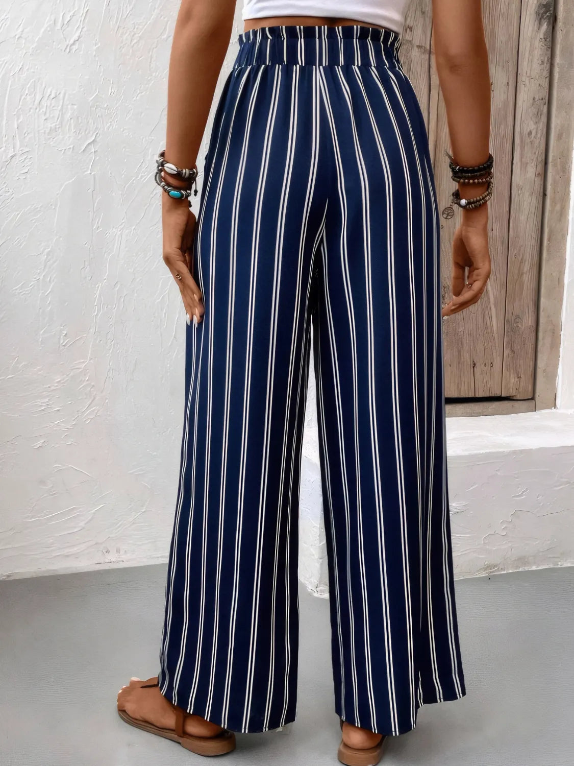 Dark navy striped wide-leg pants seen from back, elastic waistband and wide legs