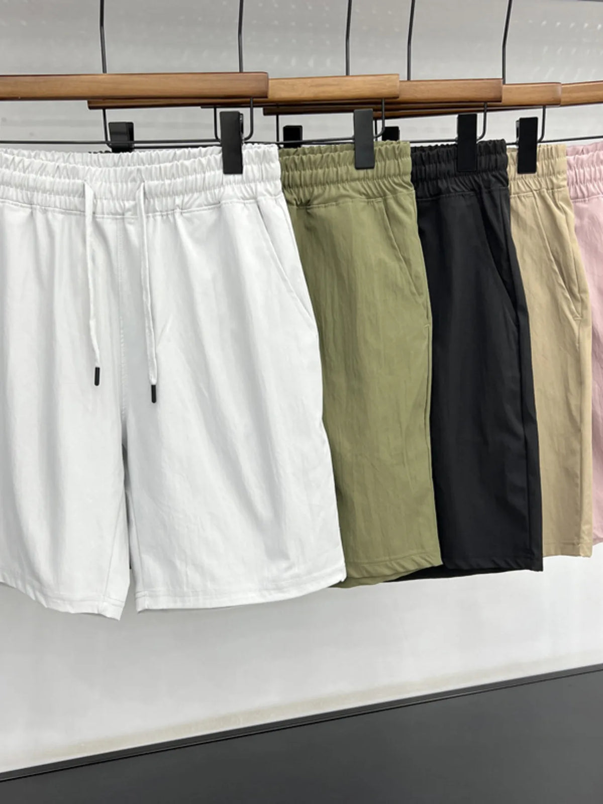 Set of men's drawstring casual shorts in white, green, black, and khaki with pockets