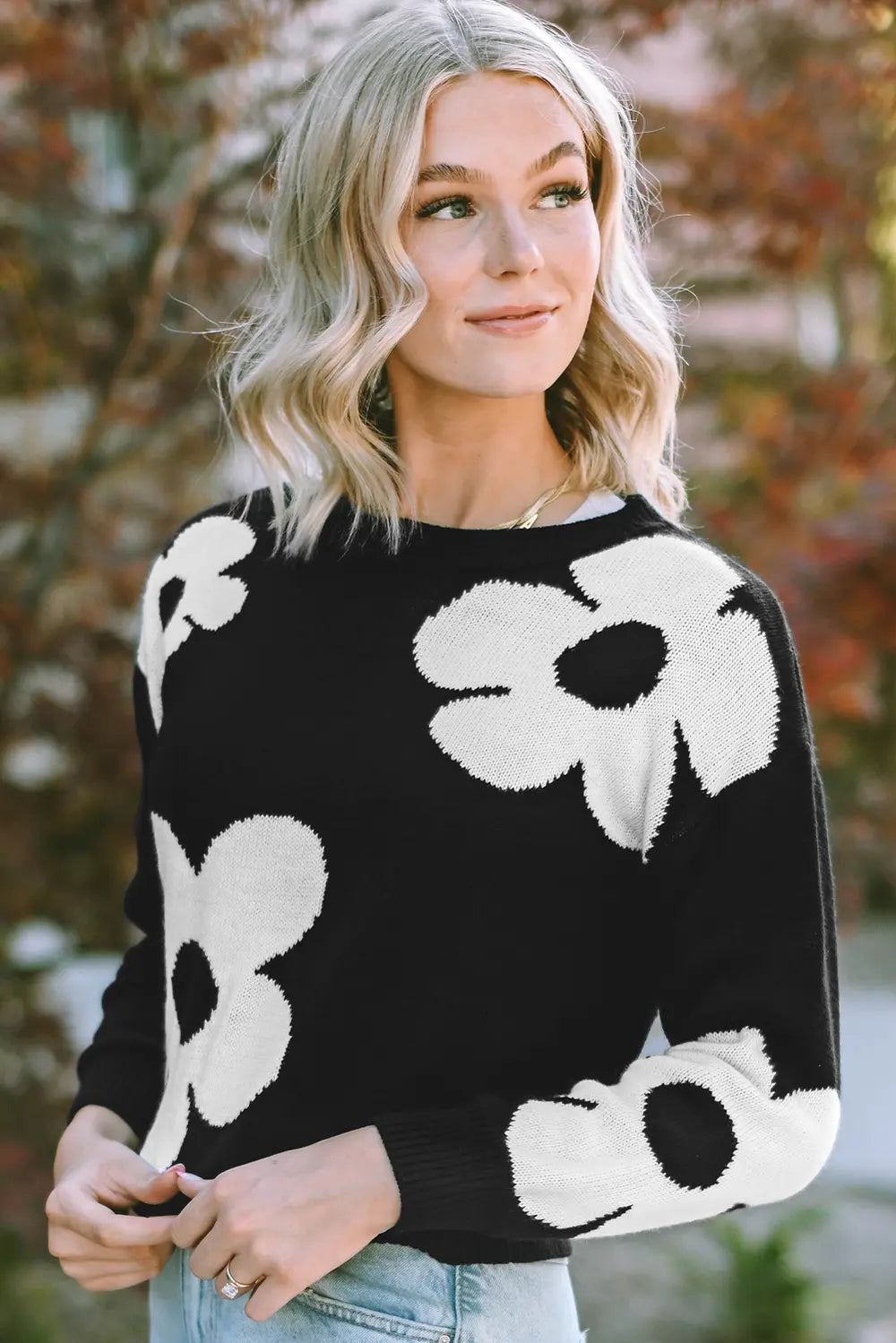 Black long-sleeve sweater with white floral pattern at chest and sleeves