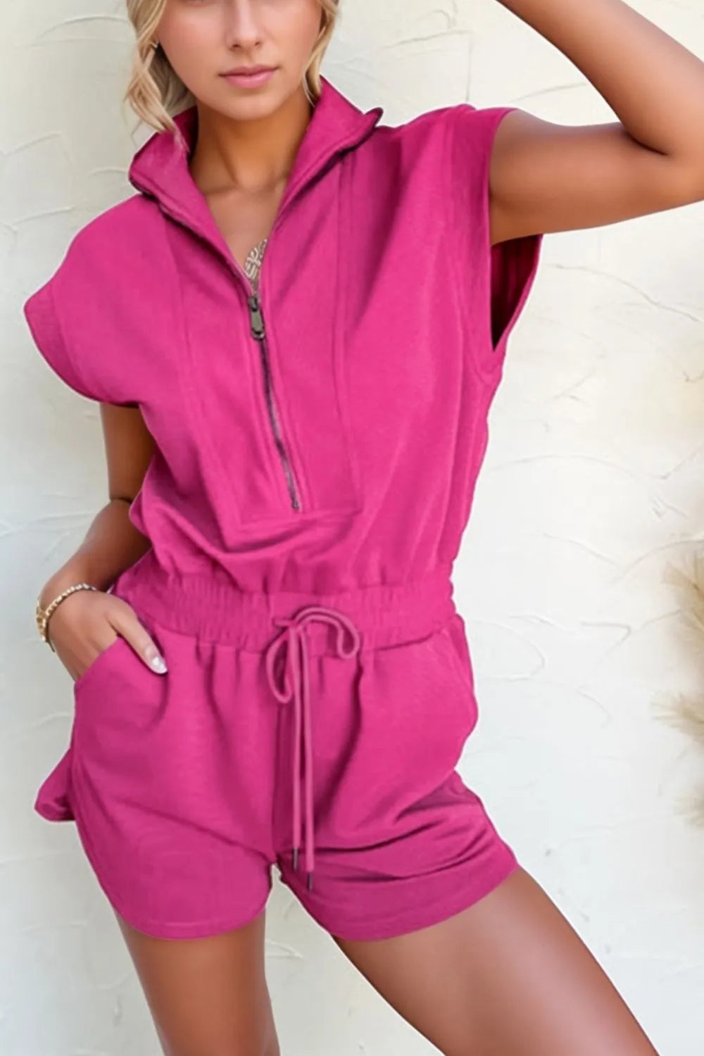 Hot pink textured romper front view, half-zip placket and drawstring waist with shorts