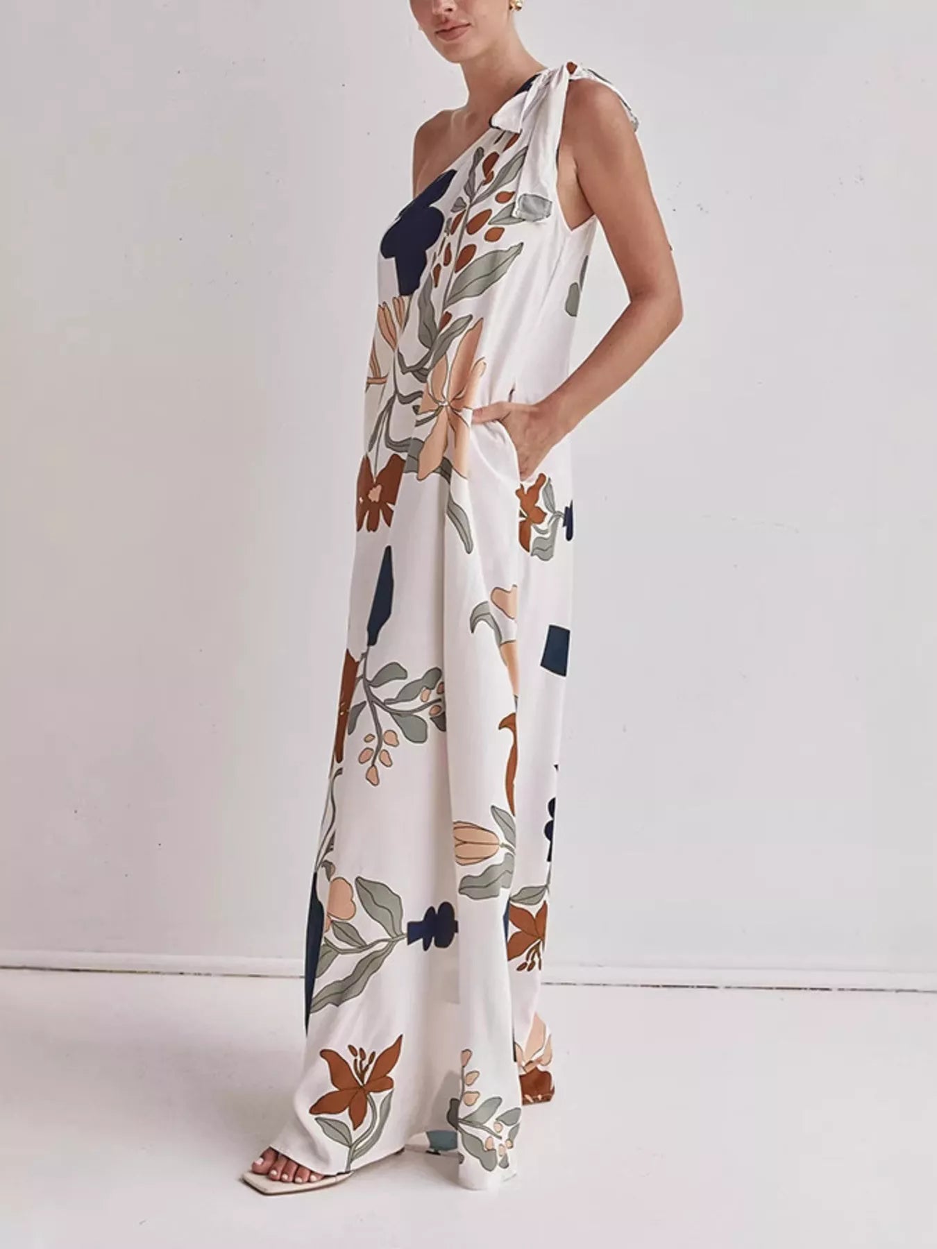Cedar & Moore Trendsi Bohemian Floral Print One-Shoulder Maxi Dress with pockets; white base and multicolor botanical print.