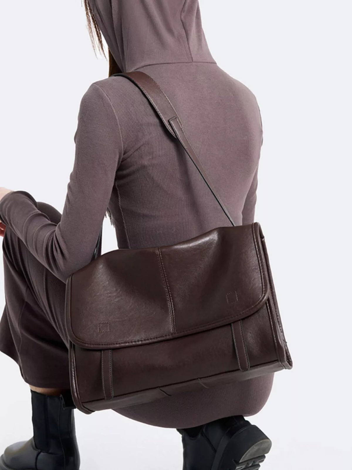 Brown messenger shoulder bag with front flap, buckle strap, and structured side panels