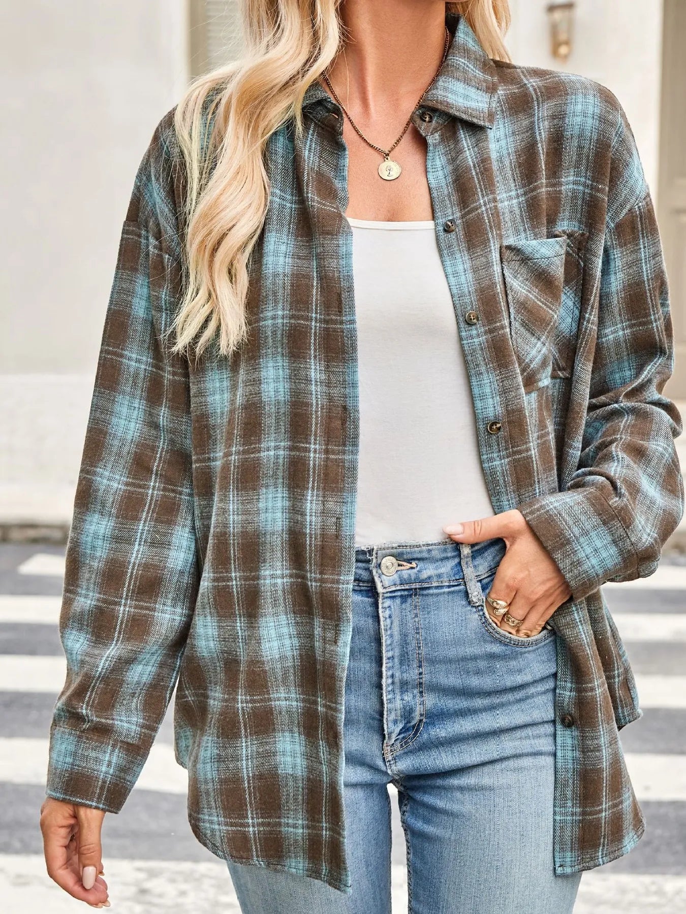 Plaid button-up long sleeve shirt with turquoise grid lines on dark brown fabric; chest pocket