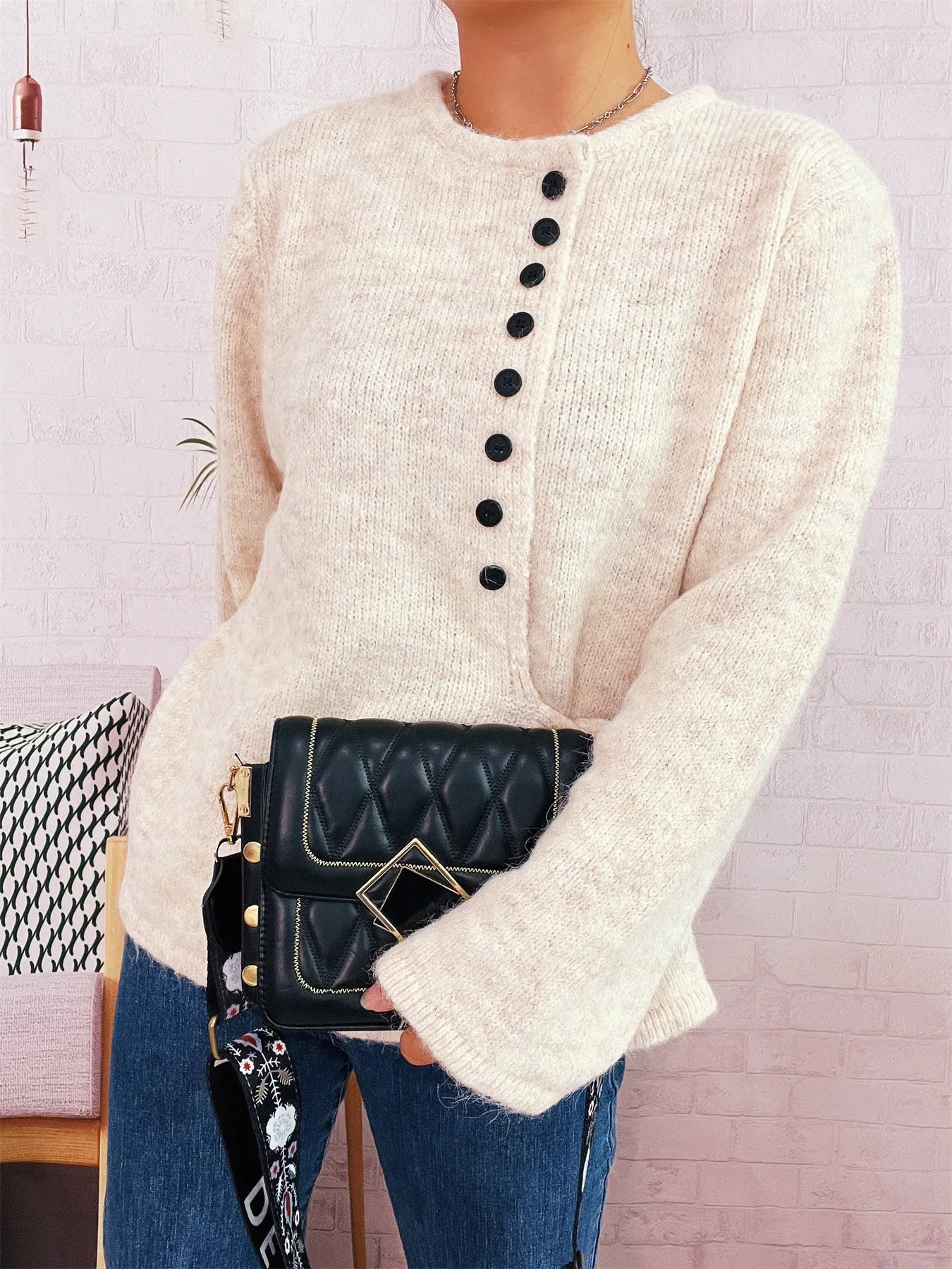 Apricot knit button-front side-tie sweater with long sleeves and black button placket
