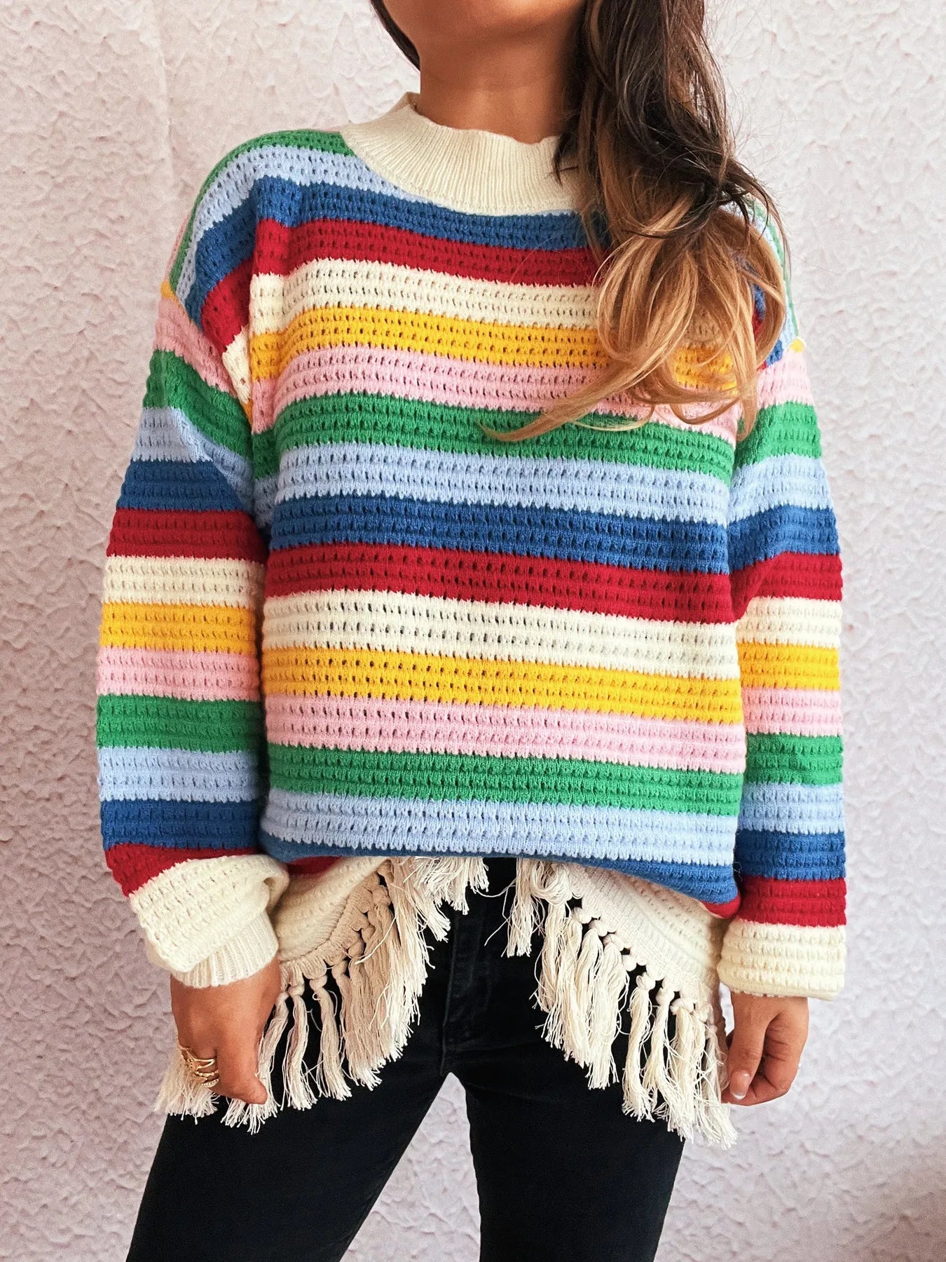 Rainbow striped long sleeve sweater with cream neckline and tassel fringe hem