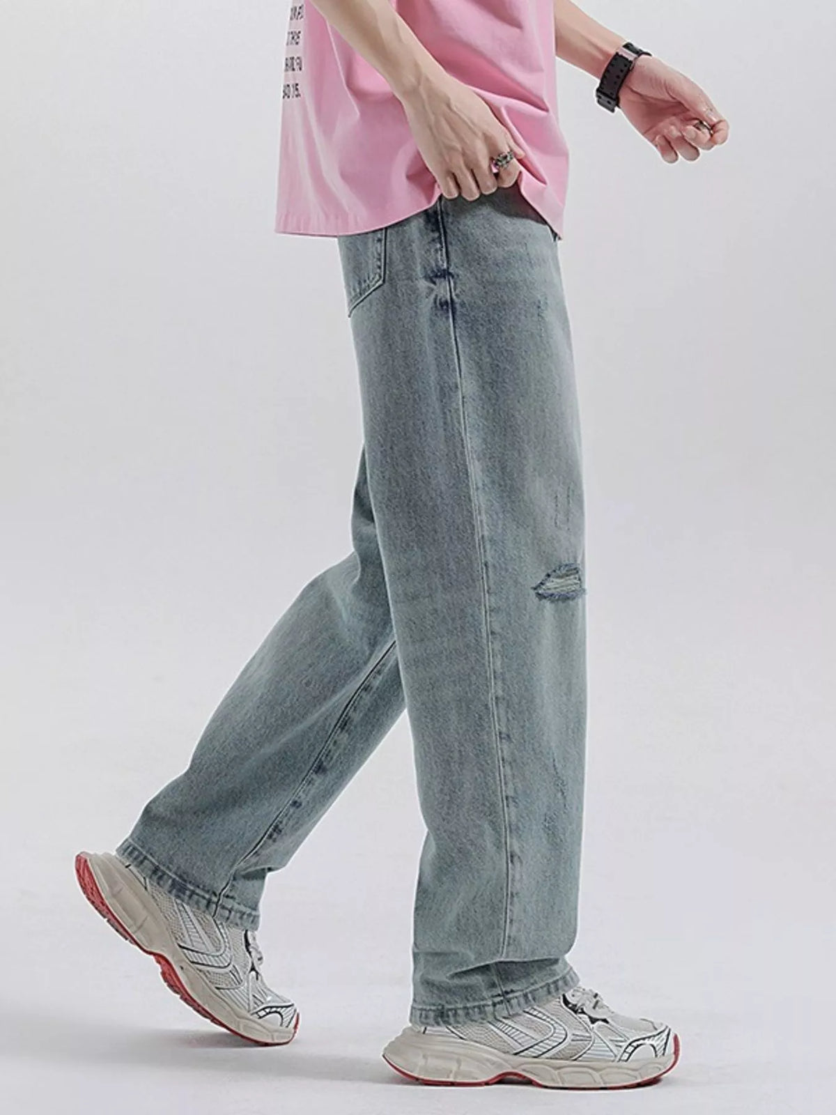 Light blue wide-leg distressed jeans with knee rip and wide cuff hem