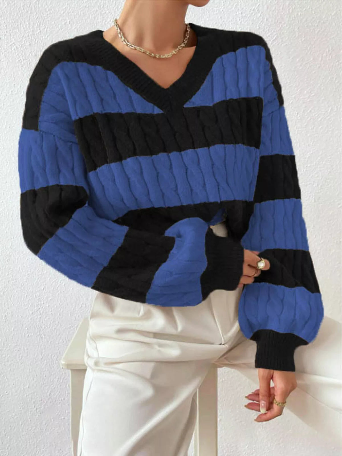 Blue and black striped cable knit V-neck sweater with long ribbed sleeves