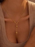 Gold-plated pendant necklace with star and cross charms on a fine chain
