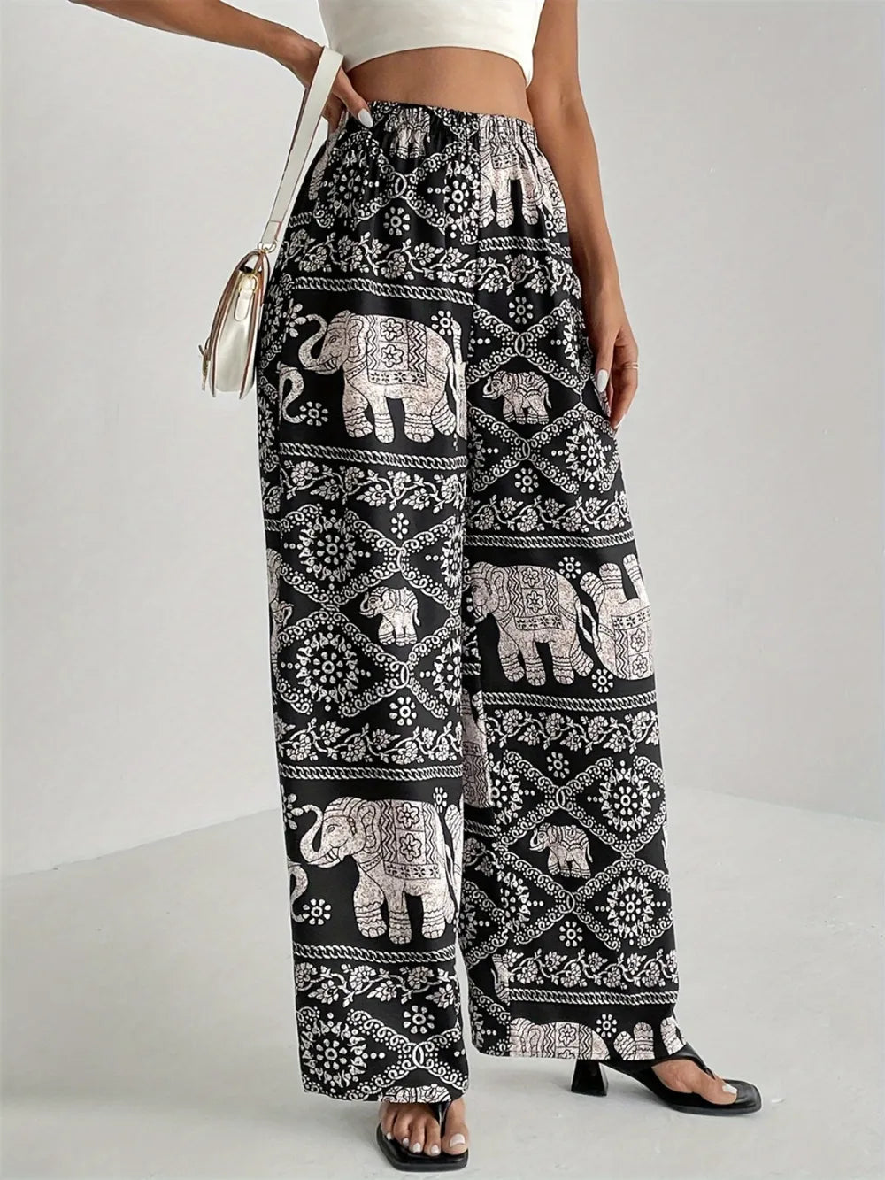Black printed wide-leg pants with elephant motifs and geometric medallion pattern