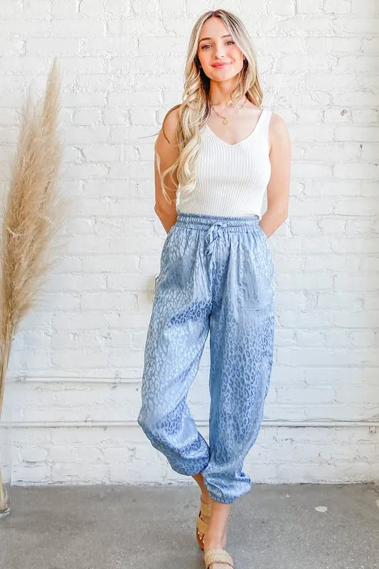 Pale blue satin leopard print joggers with elastic waistband and ankle cuffs
