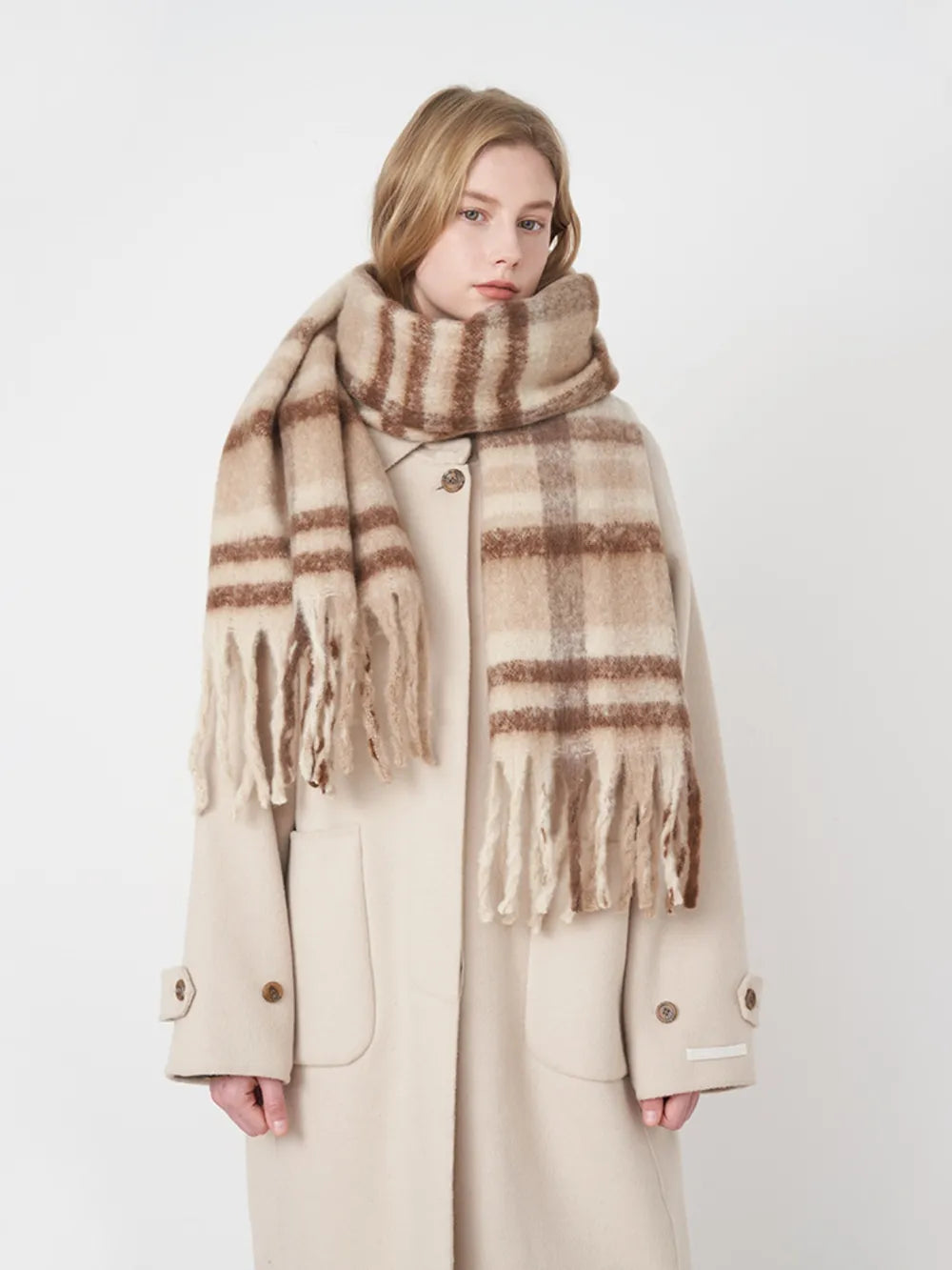 Plaid polyester scarf in beige and brown with fringe trim.
