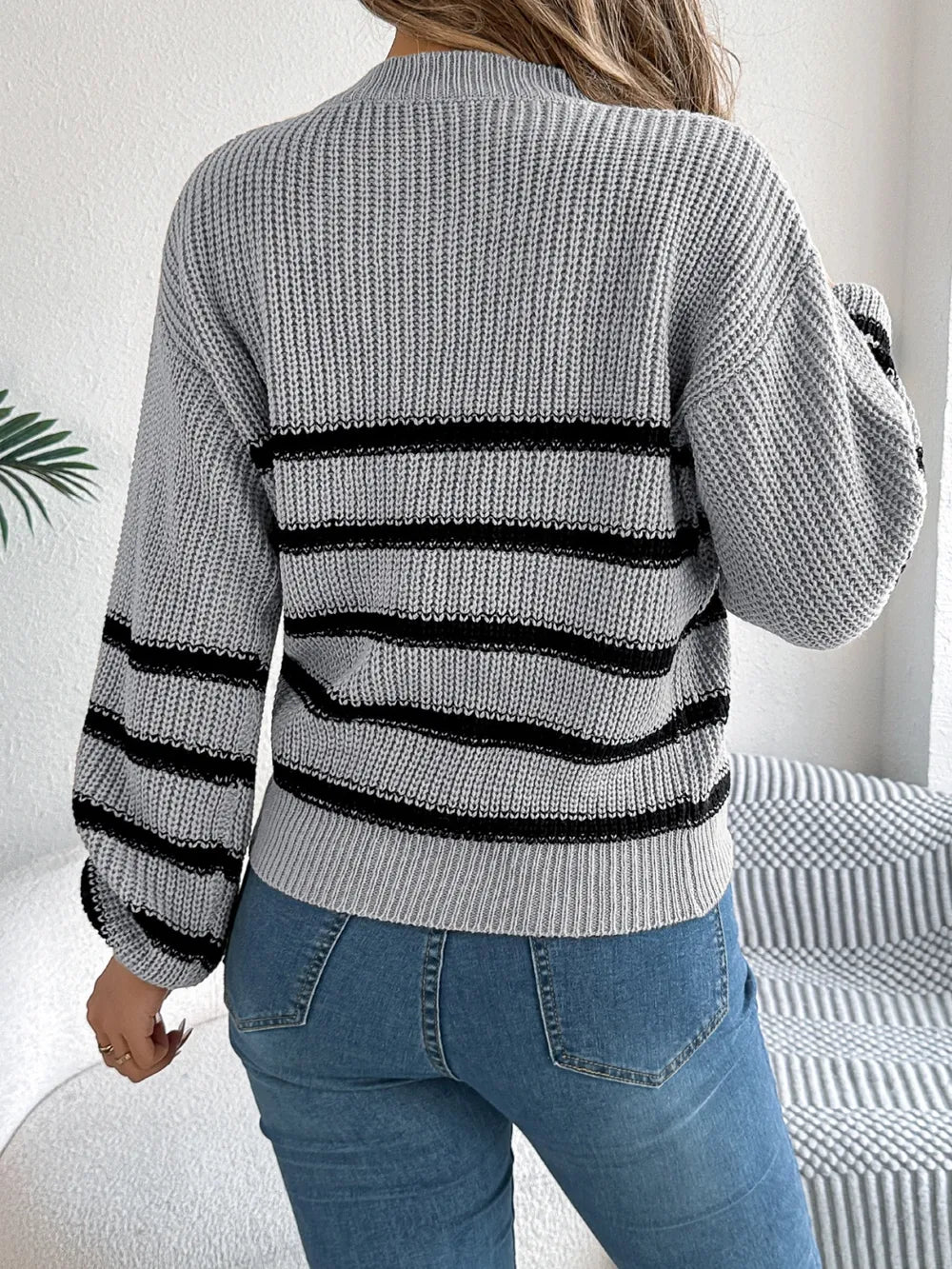 Gray striped knit sweater back view with round neck, long sleeves, black banding