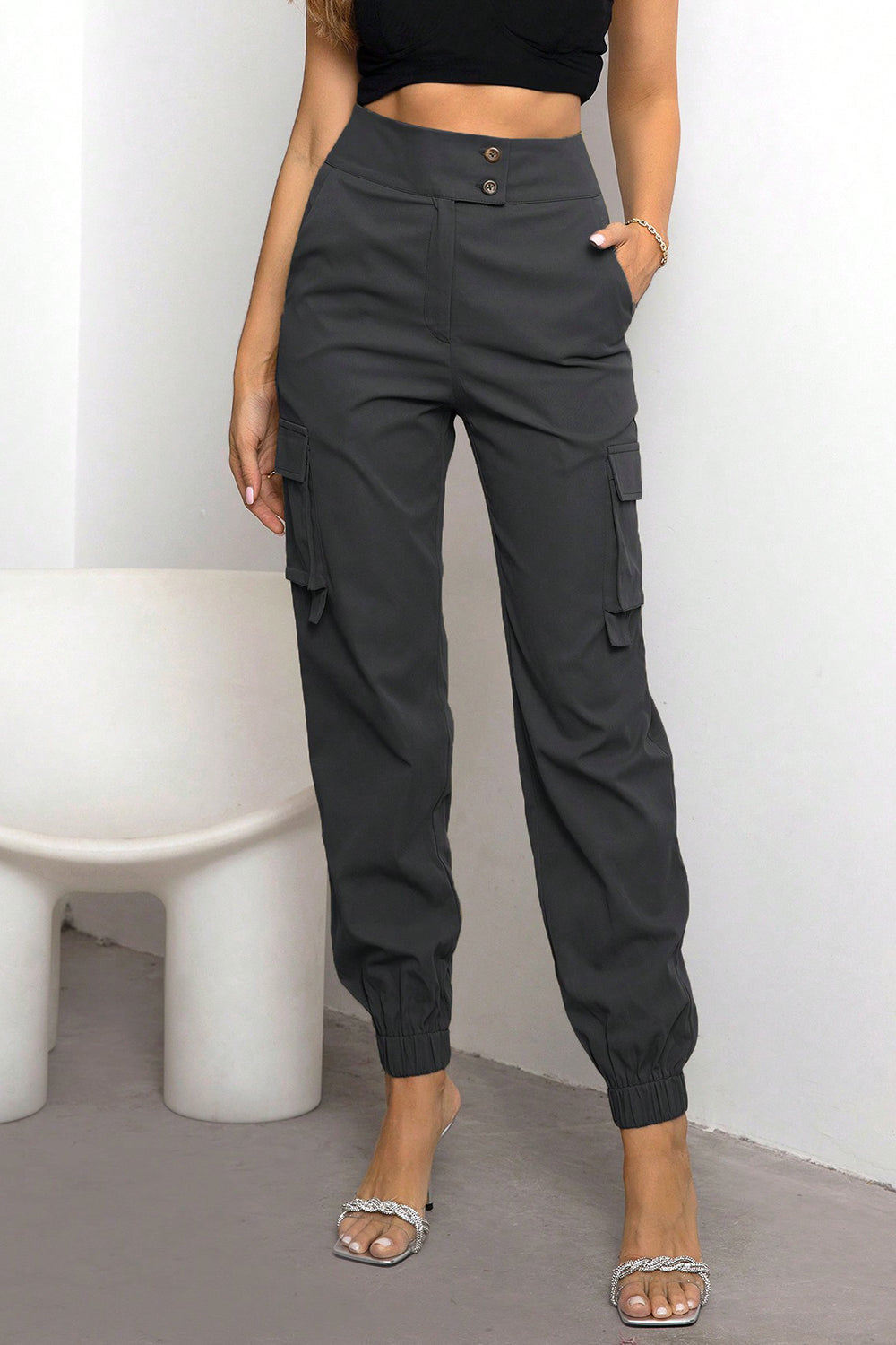 High-waist cargo pants, dark black with button front, side cargo pockets, cuffed ankle joggers