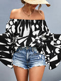 Off-shoulder bell sleeve blouse in black with bold white abstract print