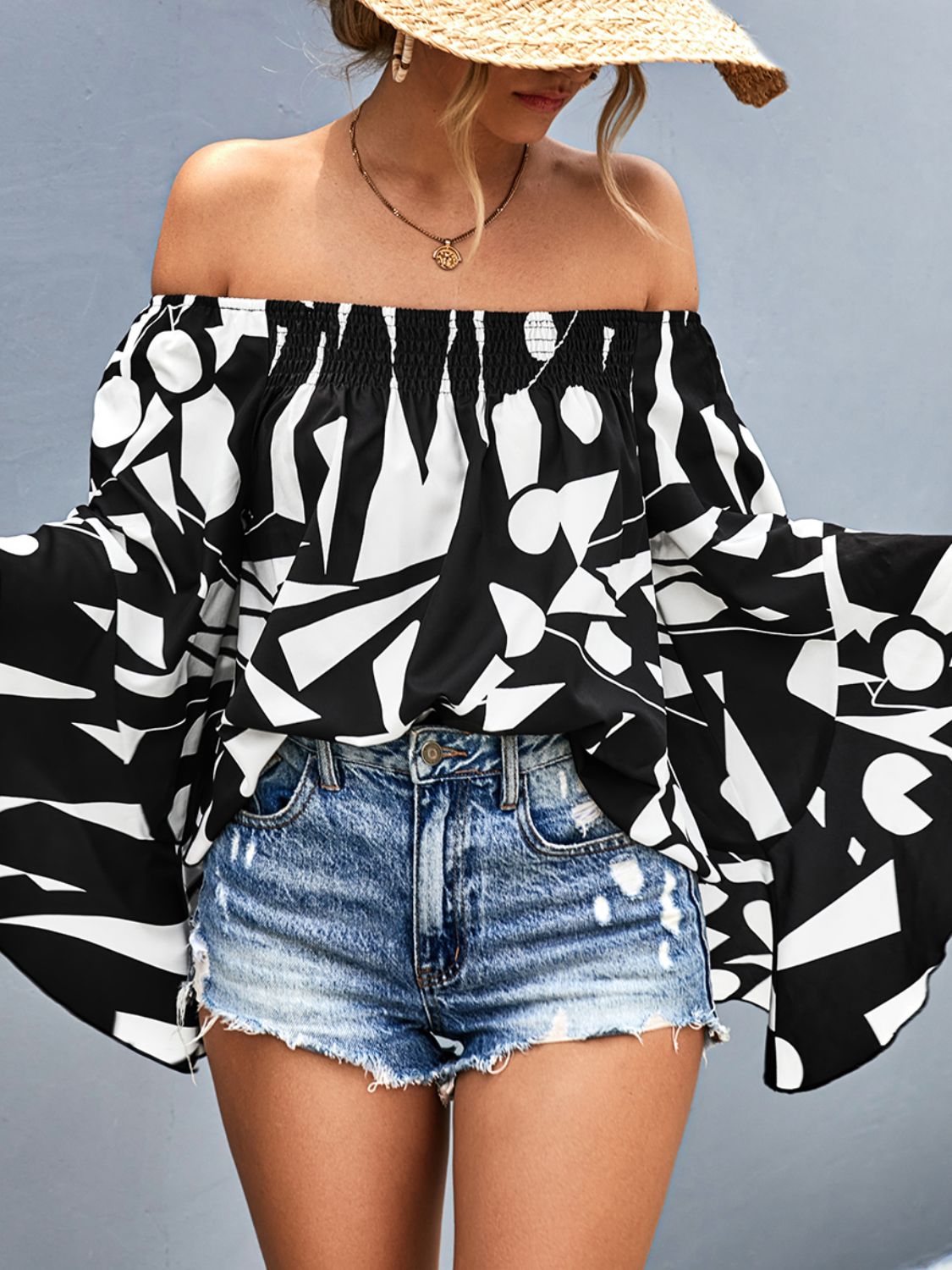 Off-shoulder bell sleeve blouse in black with bold white abstract print