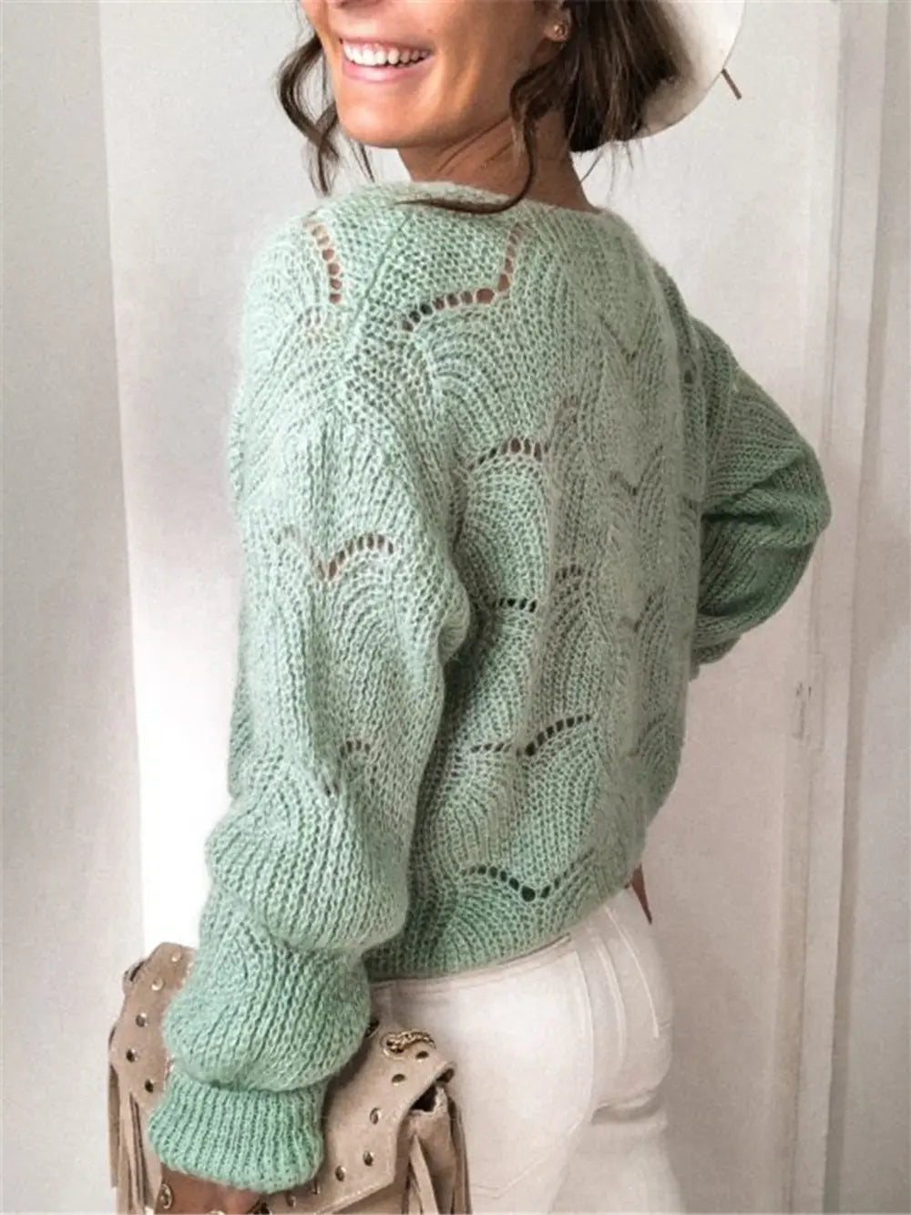 Light green openwork button-up cardigan from the back, long ribbed sleeves, knit detail.
