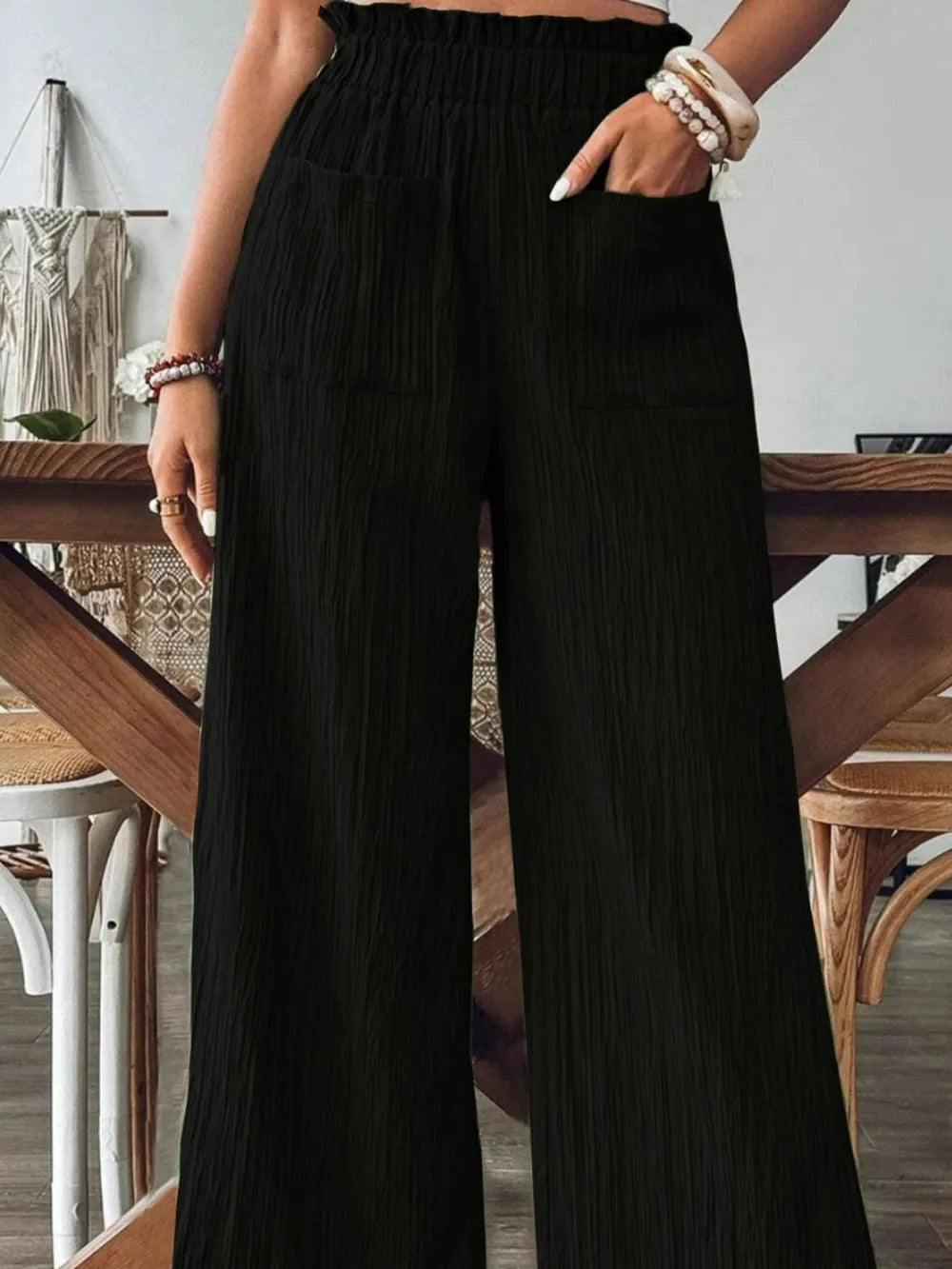Frill wide-leg pants in black with textured fabric, elastic waist, side pockets