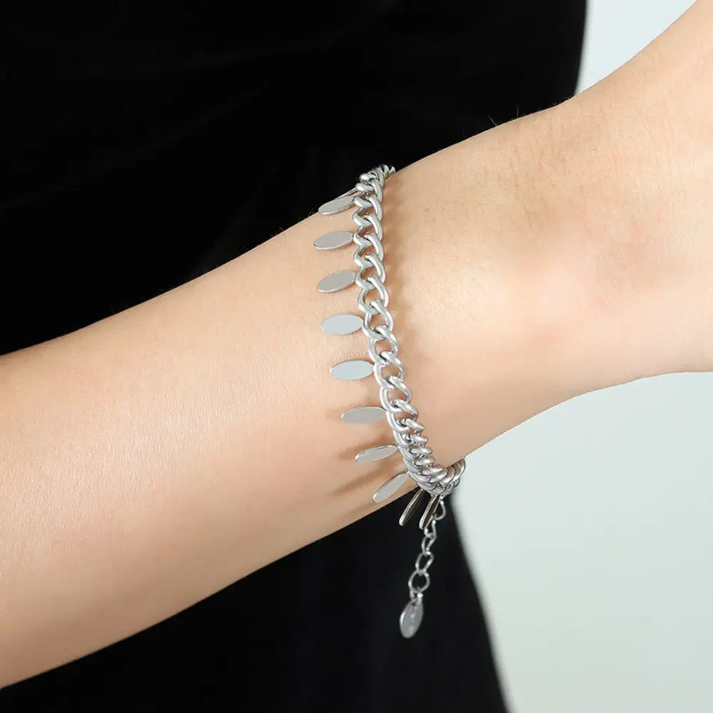 Silver leaf charm bracelet with linked chain and multiple leaf-shaped charms on wrist