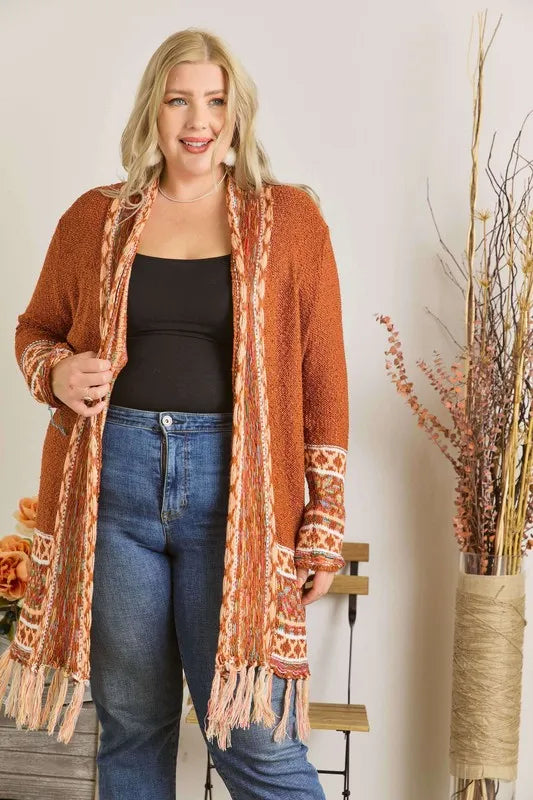 Rust cardigan with aztec trim, fringe sleeves, open front over dark top