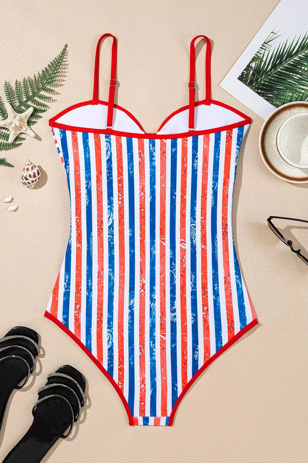 One-piece swimsuit flat lay front view with red straps and vertical blue-white stripes