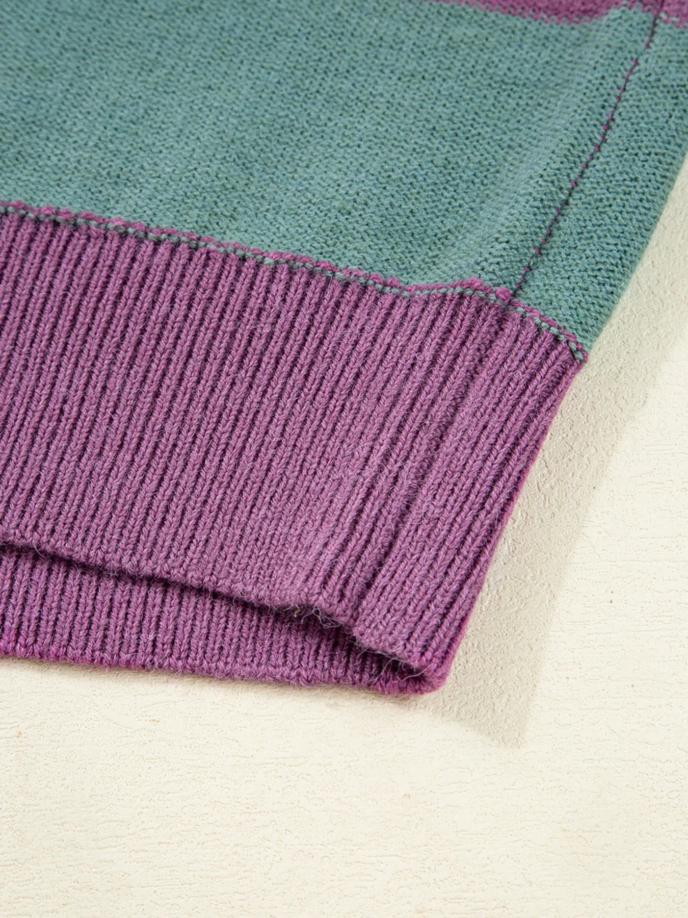 Ribbed hem cuff detail on multicolor striped sweater with purple knit band