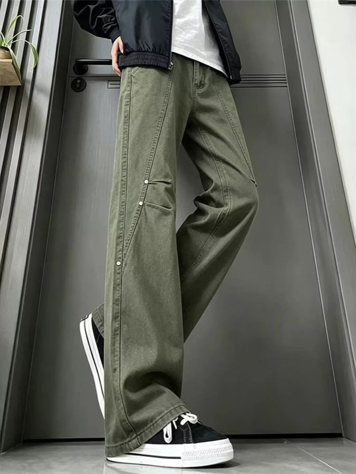 Wide-leg green denim jeans with front fly and buttoned side panels