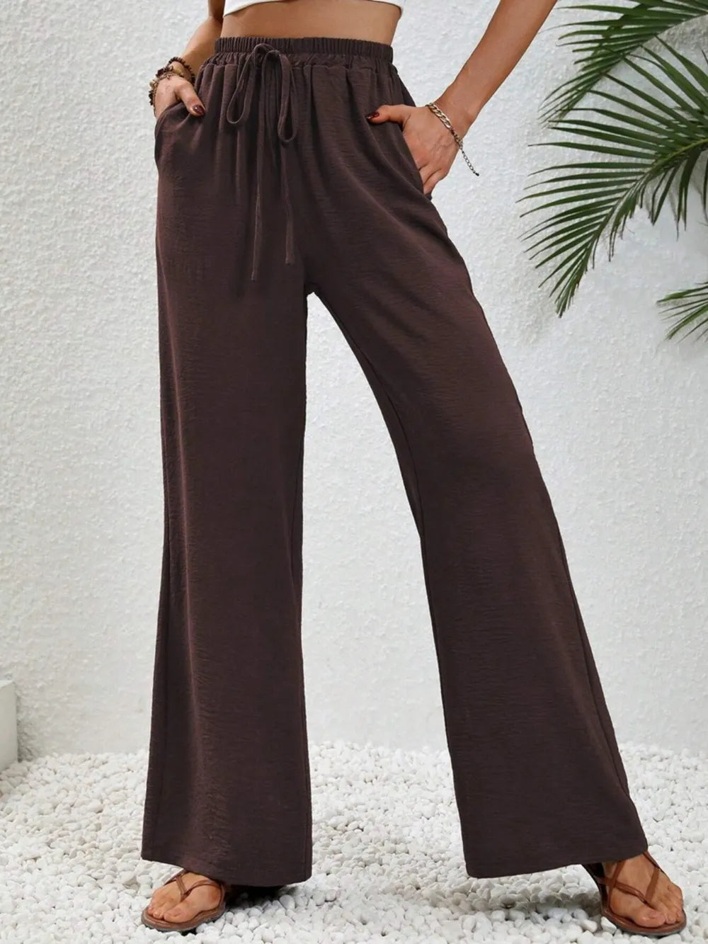 Dark brown wide-leg drawstring pants with elastic waistband and tie waist