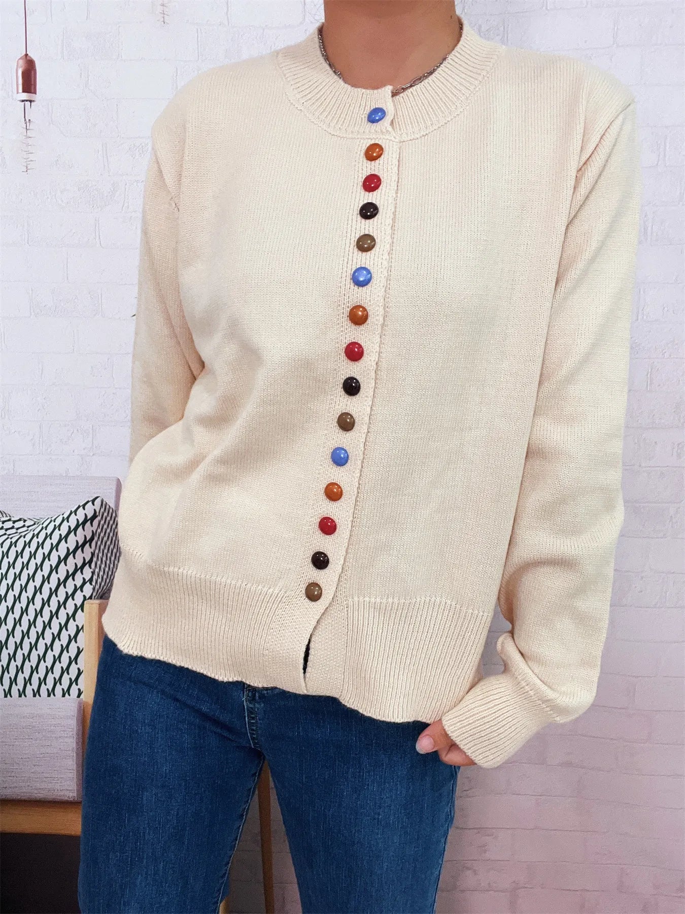 Cream button-front cardigan with crew neck and vertical multicolor button row