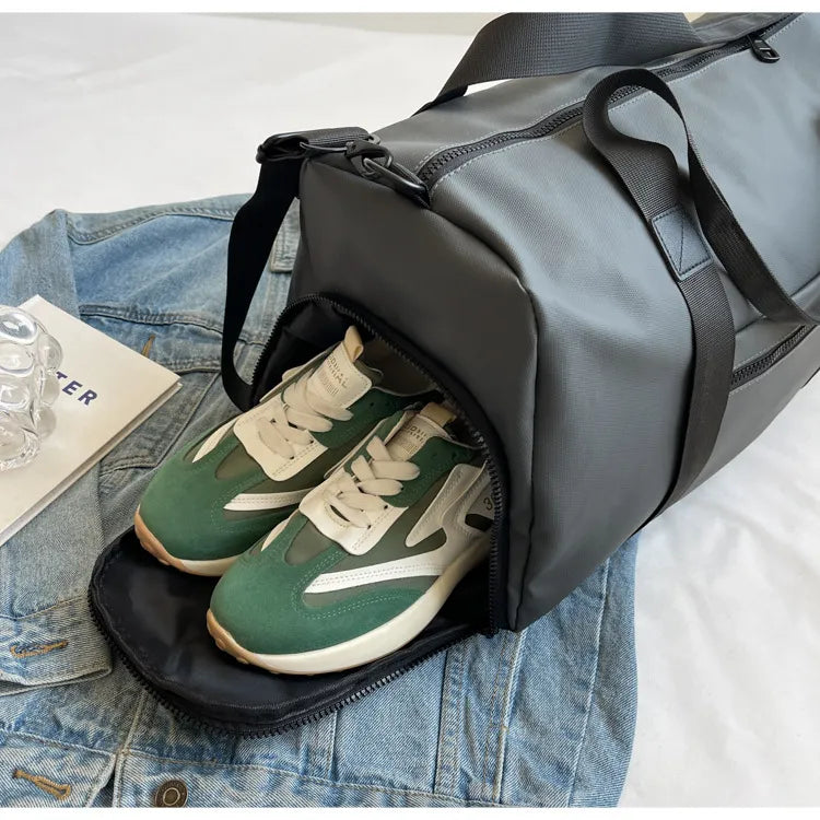 Dark gray waterproof duffel bag with side zipper open, showing sneakers inside