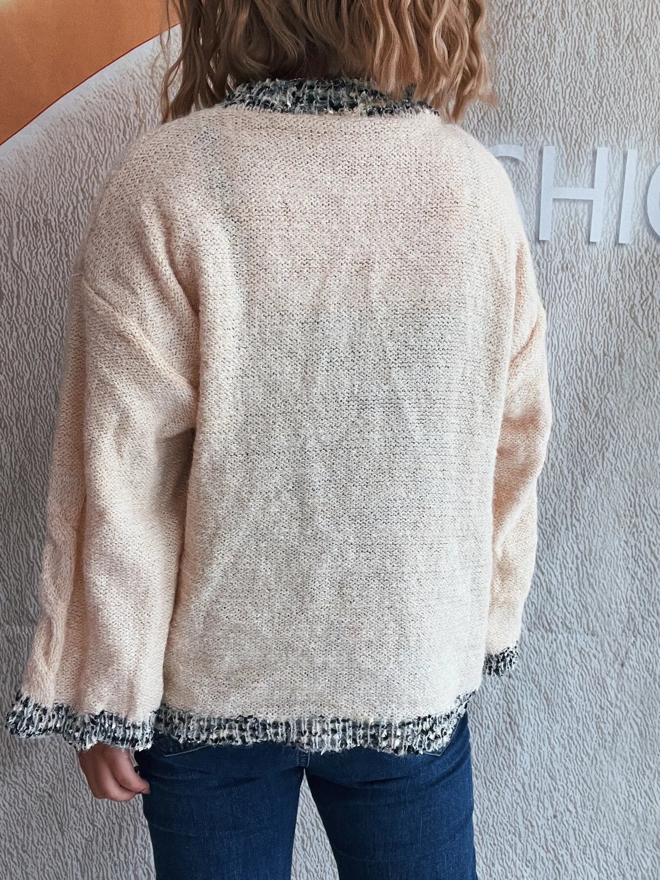 Apricot round-neck sweater, contrast trim at collar and bottom hem