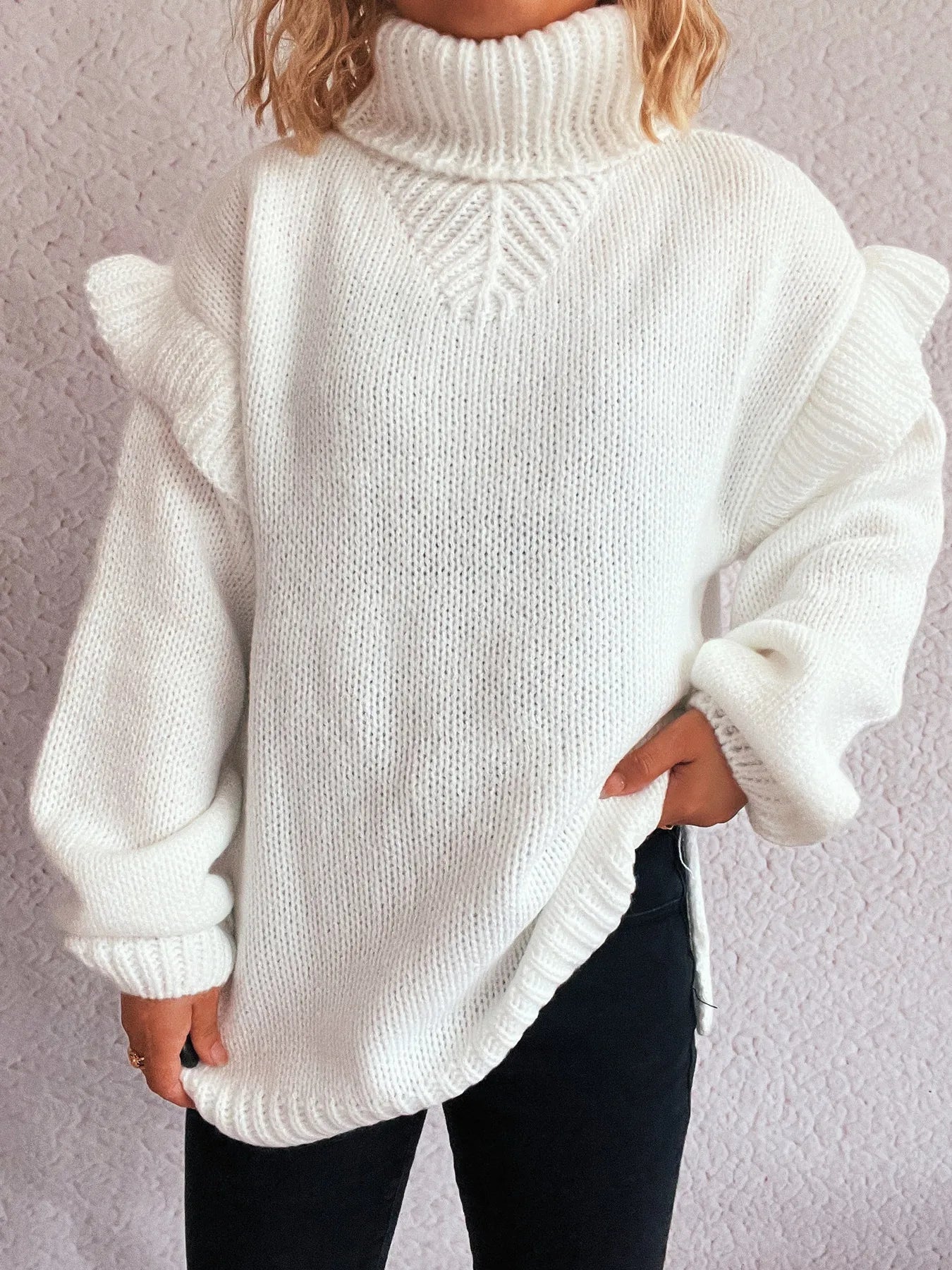 White ruffled turtleneck sweater with chevron knit detail at the neck
