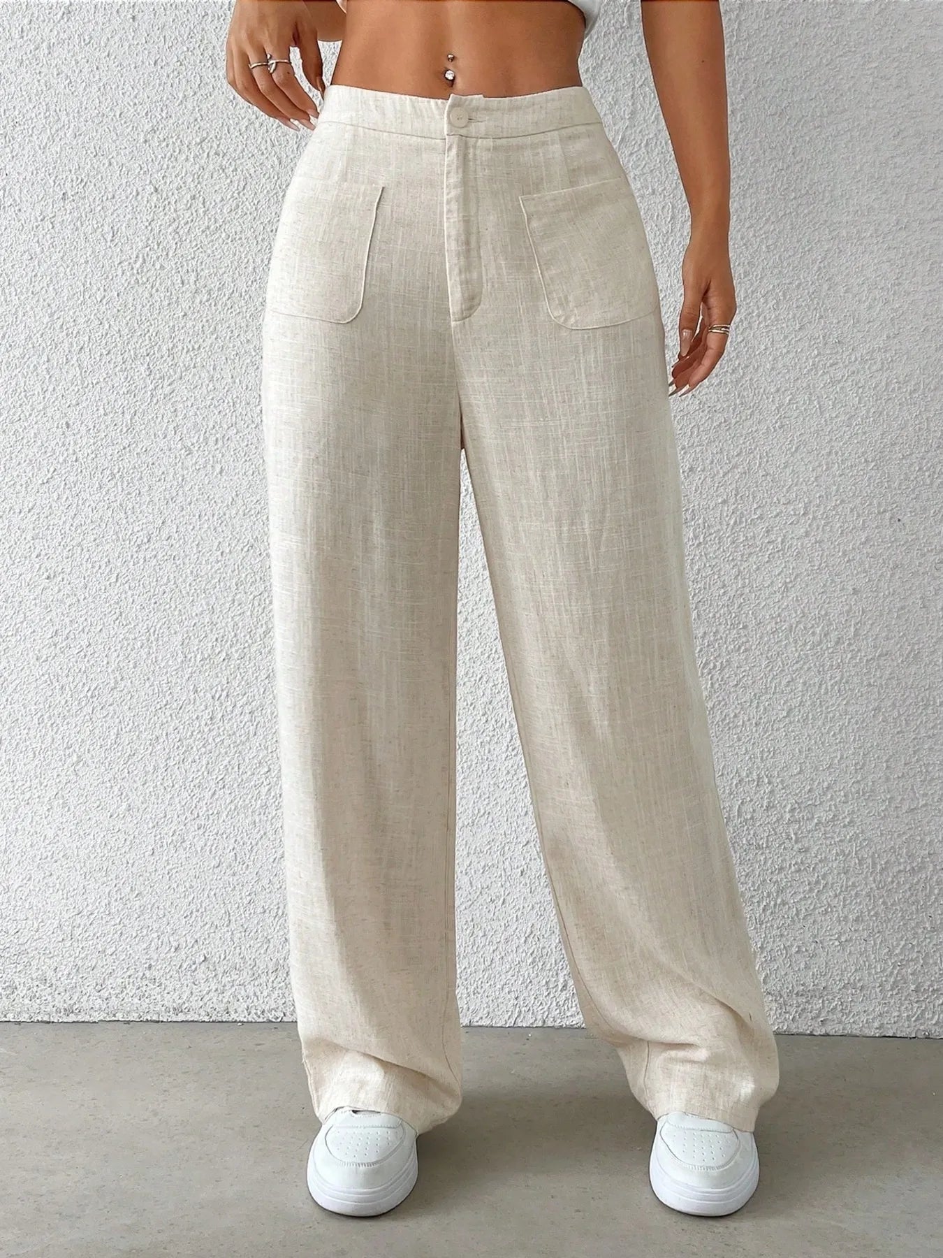Beige wide-leg pants with front pockets, center seam, and roomy loose fit.