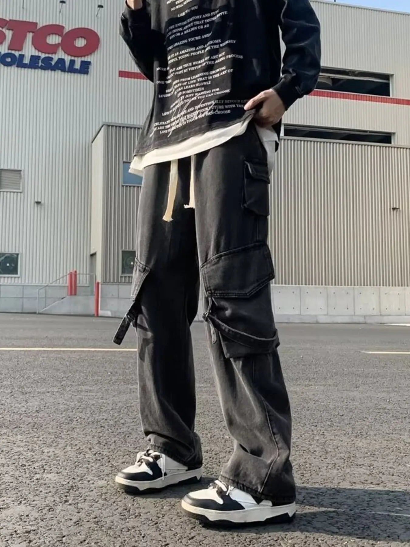 Black wide-leg cargo jeans with drawstring waist and large side cargo flap pockets
