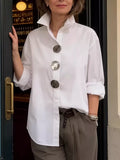 White oversized long-sleeve button shirt with metallic round buttons and point collar