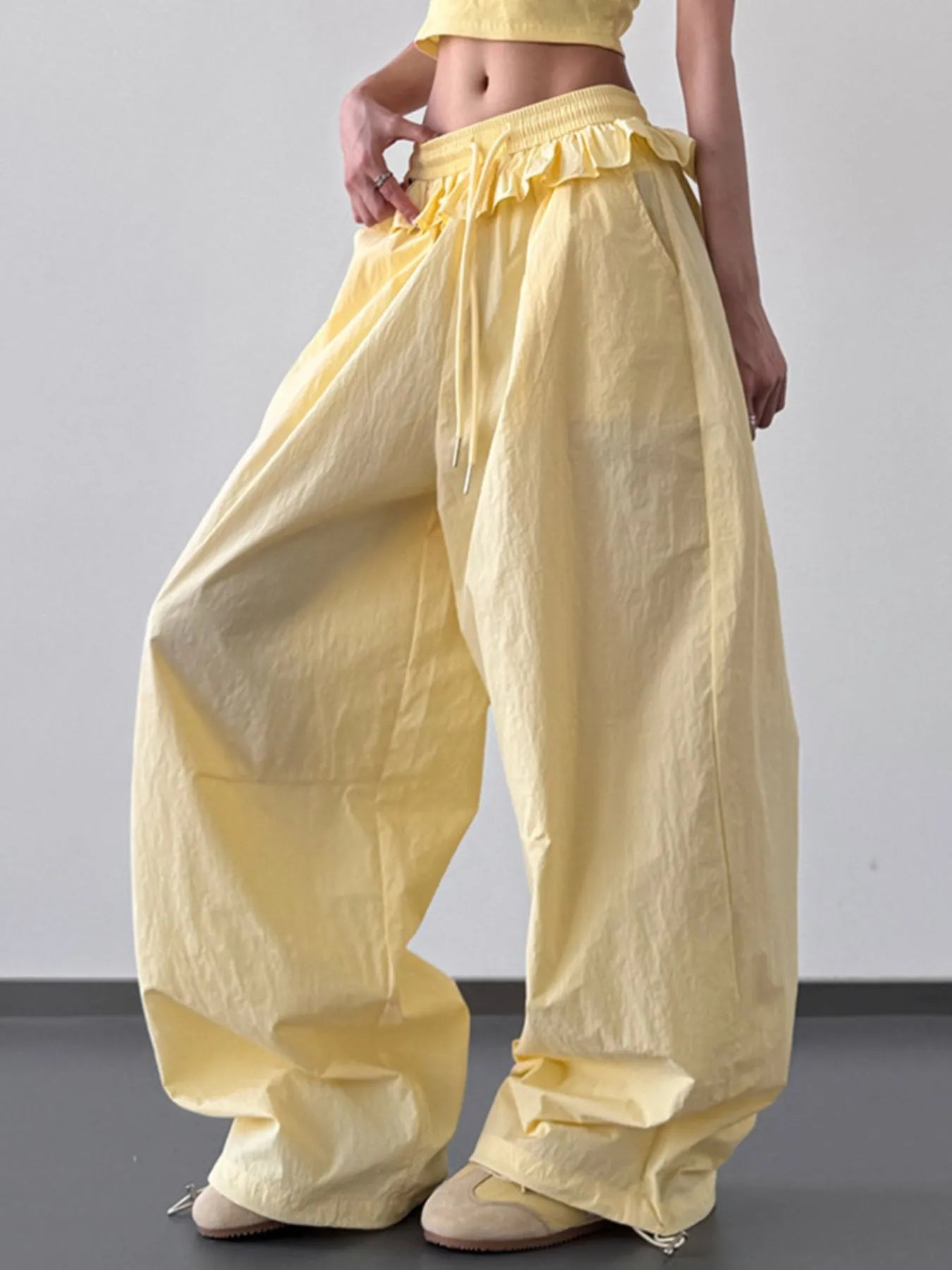 Yellow drawstring wide-leg pants with ruffled waistband and gathered cuffs