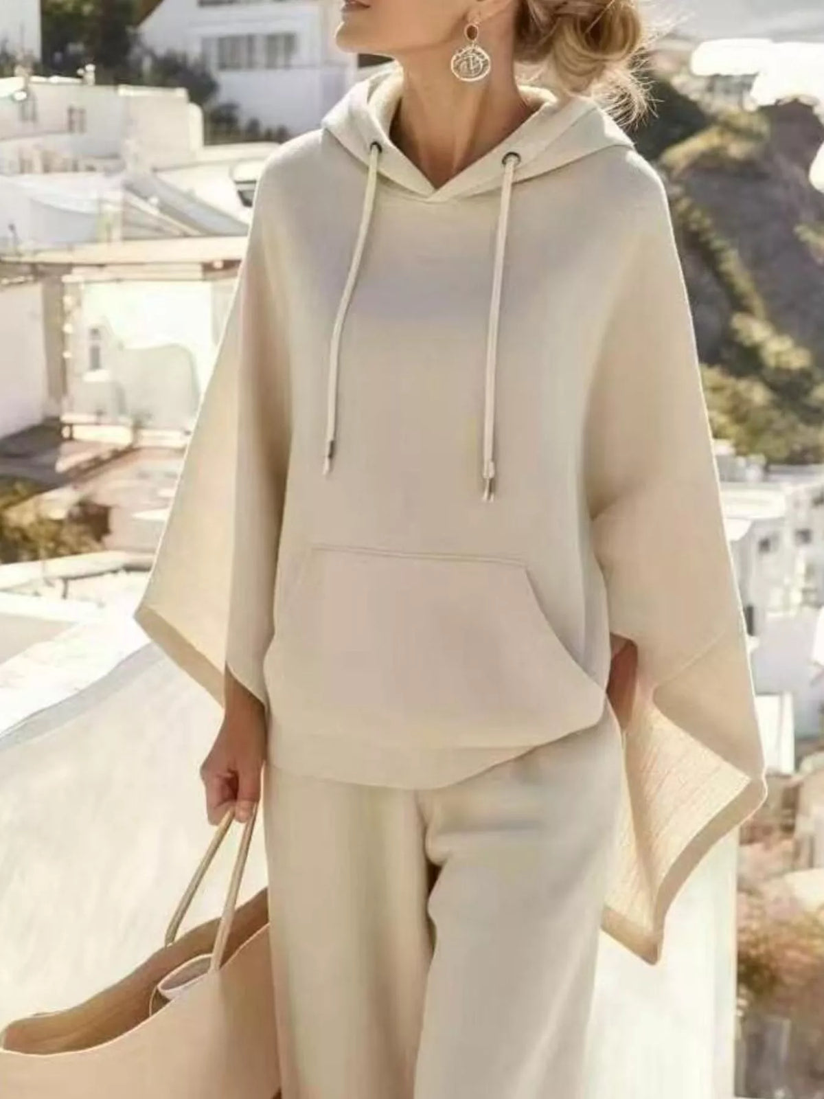 Beige hooded poncho with drawstring front pocket and matching wide-leg pants set