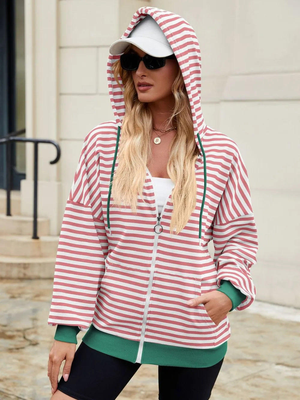 Pink-and-white striped zip-up hoodie with hood, front zipper, long sleeves.