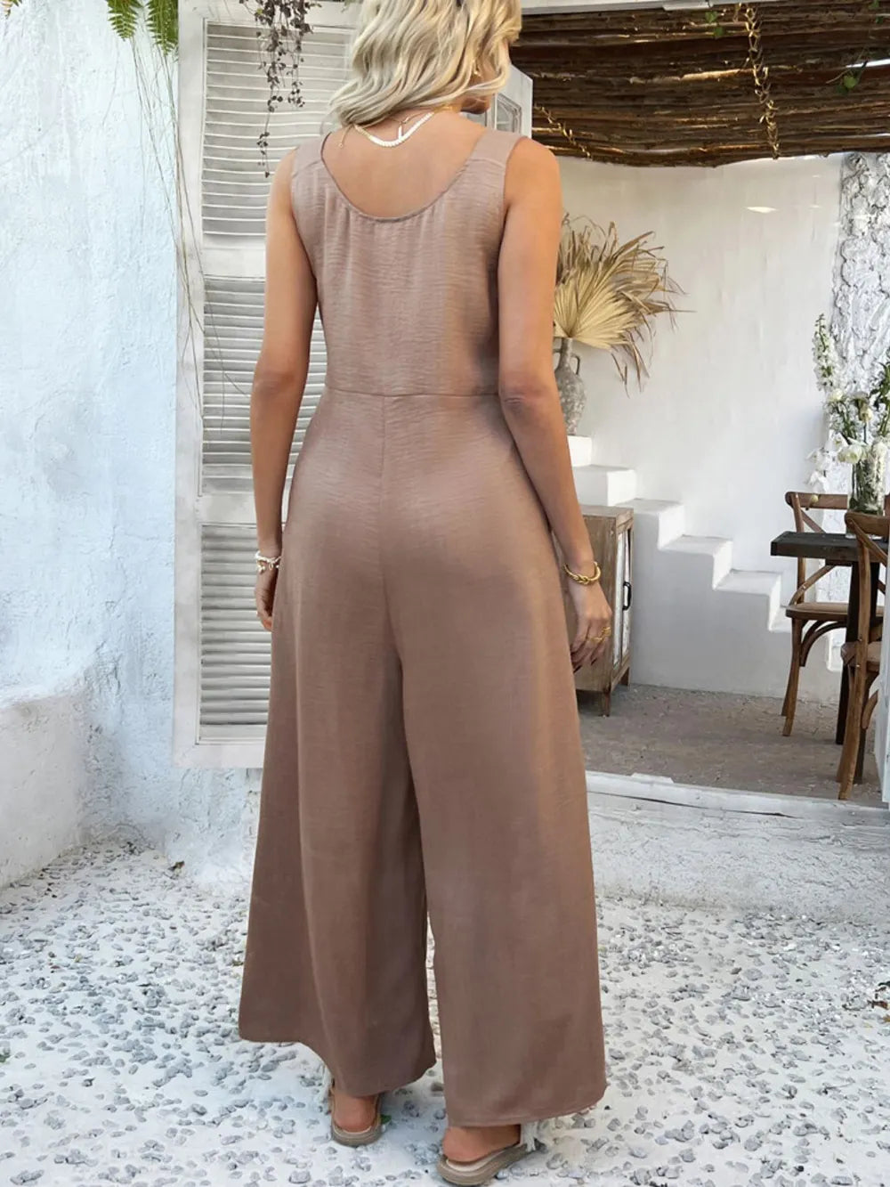 Taupe button-front wide-leg jumpsuit, open back and sleeveless cut