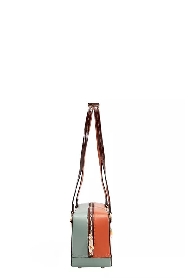 Small crossbody bag with mint and orange panels and top brown strap.