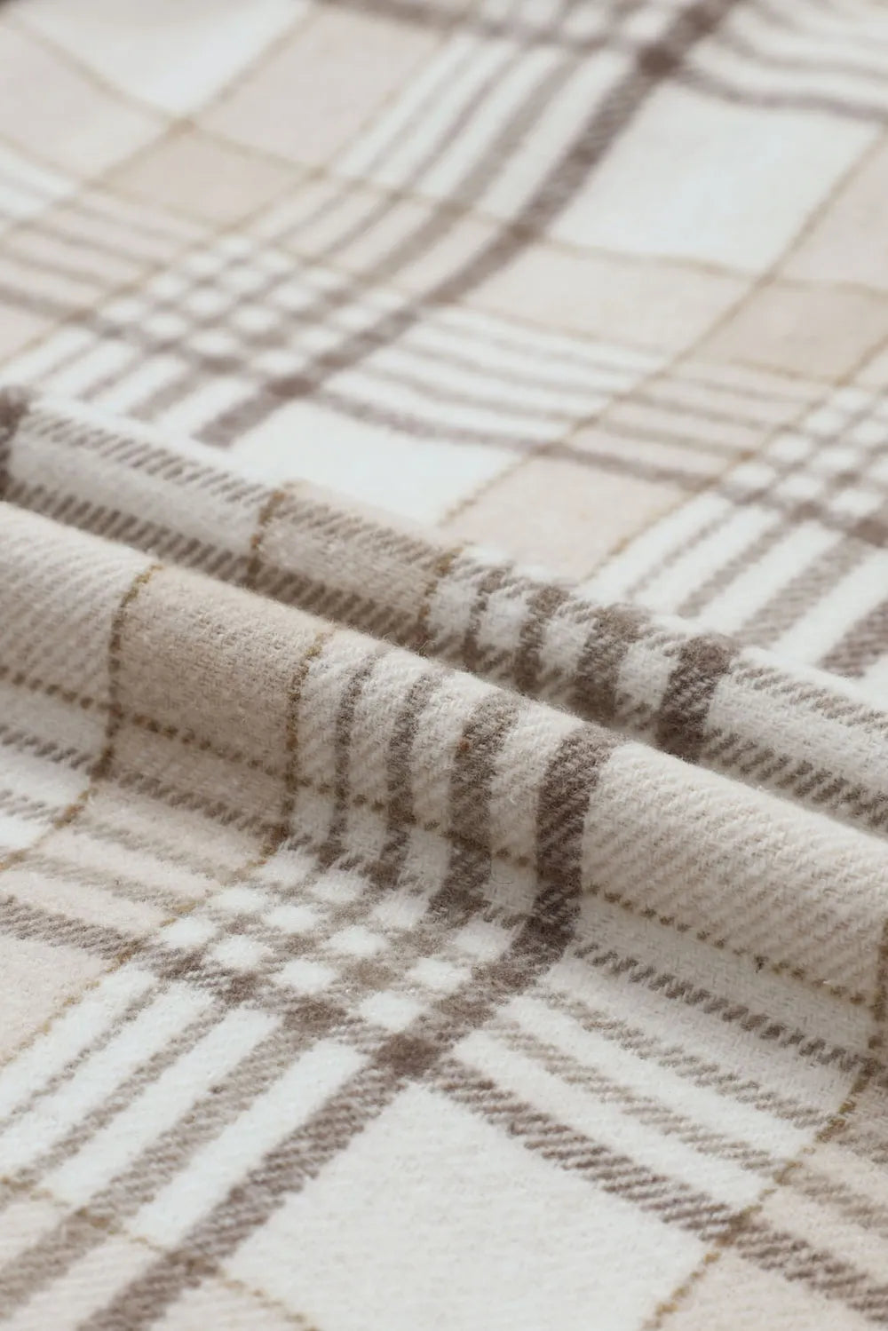 Plaid shacket fabric close-up with beige and brown check pattern