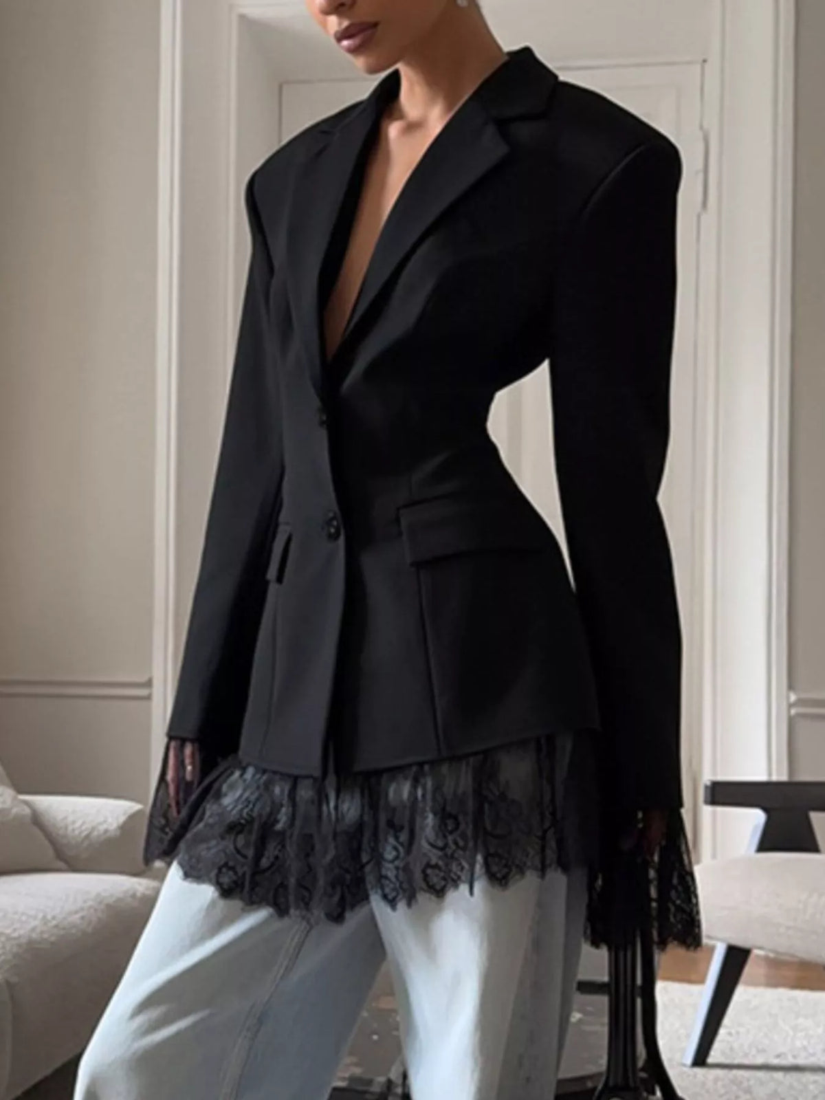 Black blazer featuring lace hem trim and flap pockets with a fitted waist.