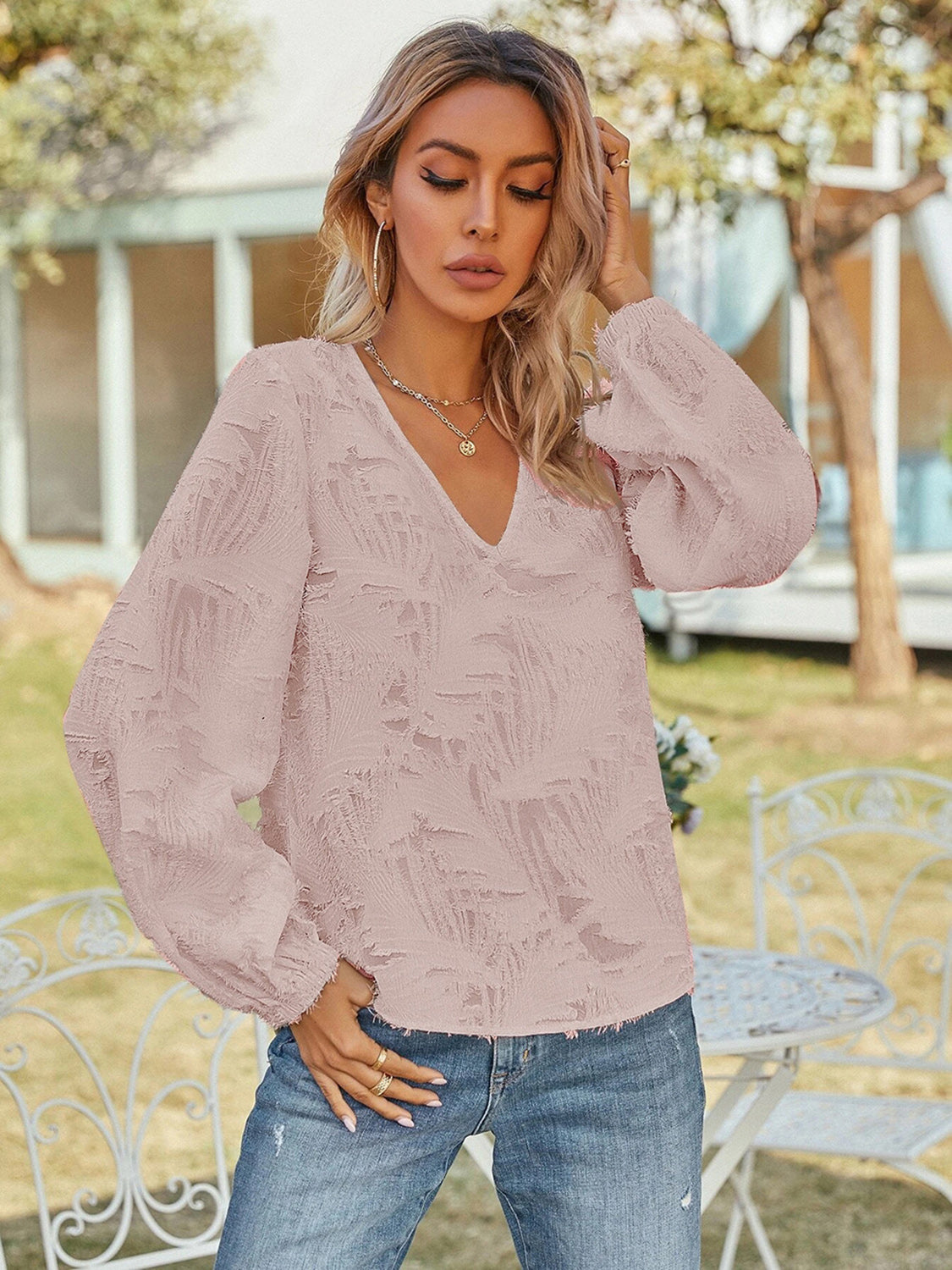 Blush pink V-neck long sleeve blouse with textured fabric and puff sleeves
