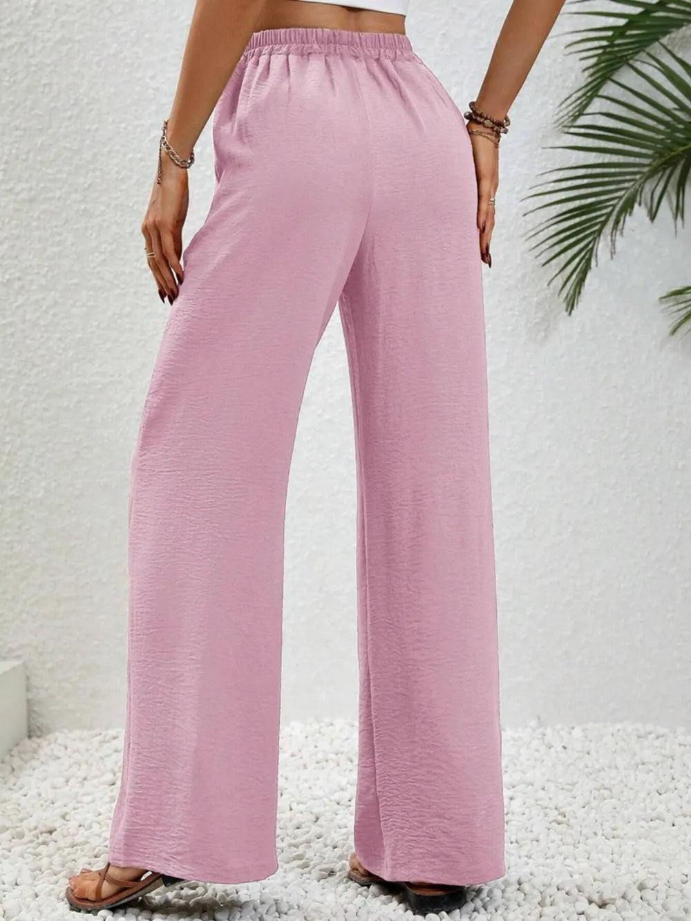 Pink wide-leg drawstring pants with gathered waist and wide straight legs