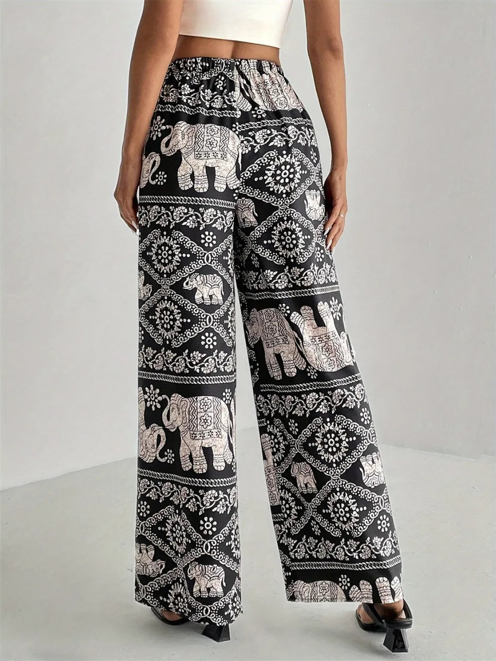 Black printed wide-leg pants with elephant motif, elastic waist and flowing wide legs