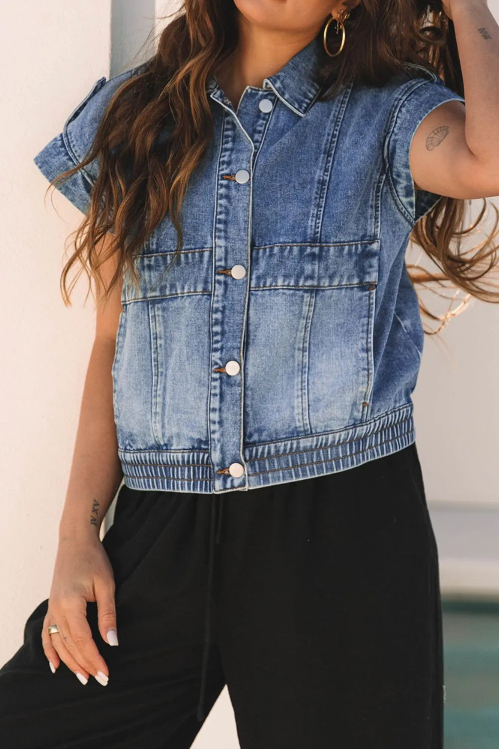 Medium-wash denim button-up cap sleeve jacket with pointed collar and chest pockets